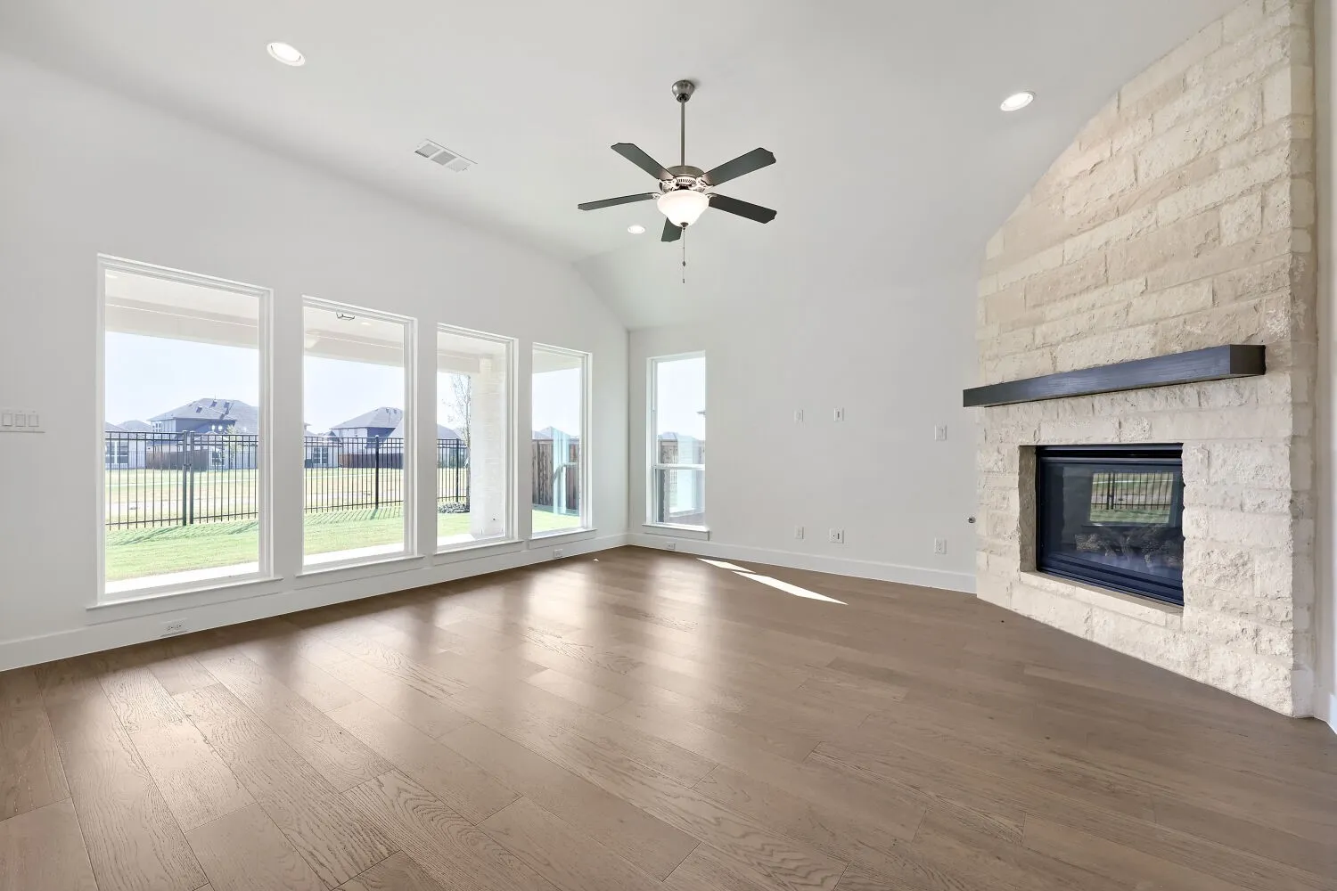 Vaulted ceiling with recessed lighting and a ceiling fan