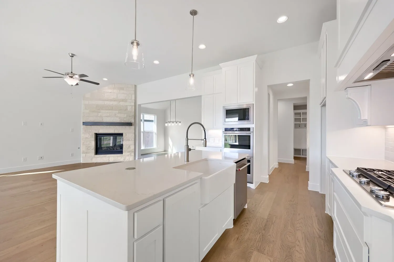 Gourmet kitchen with a large island, farmhouse sink, stainless steel appliances, and gas range