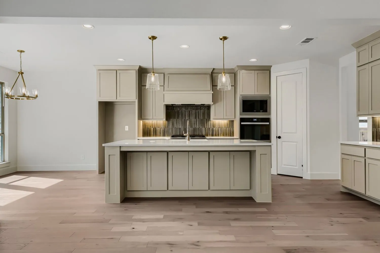 Kitchen featuring light-toned cabinetry, a central island with countertop, and recessed lighting