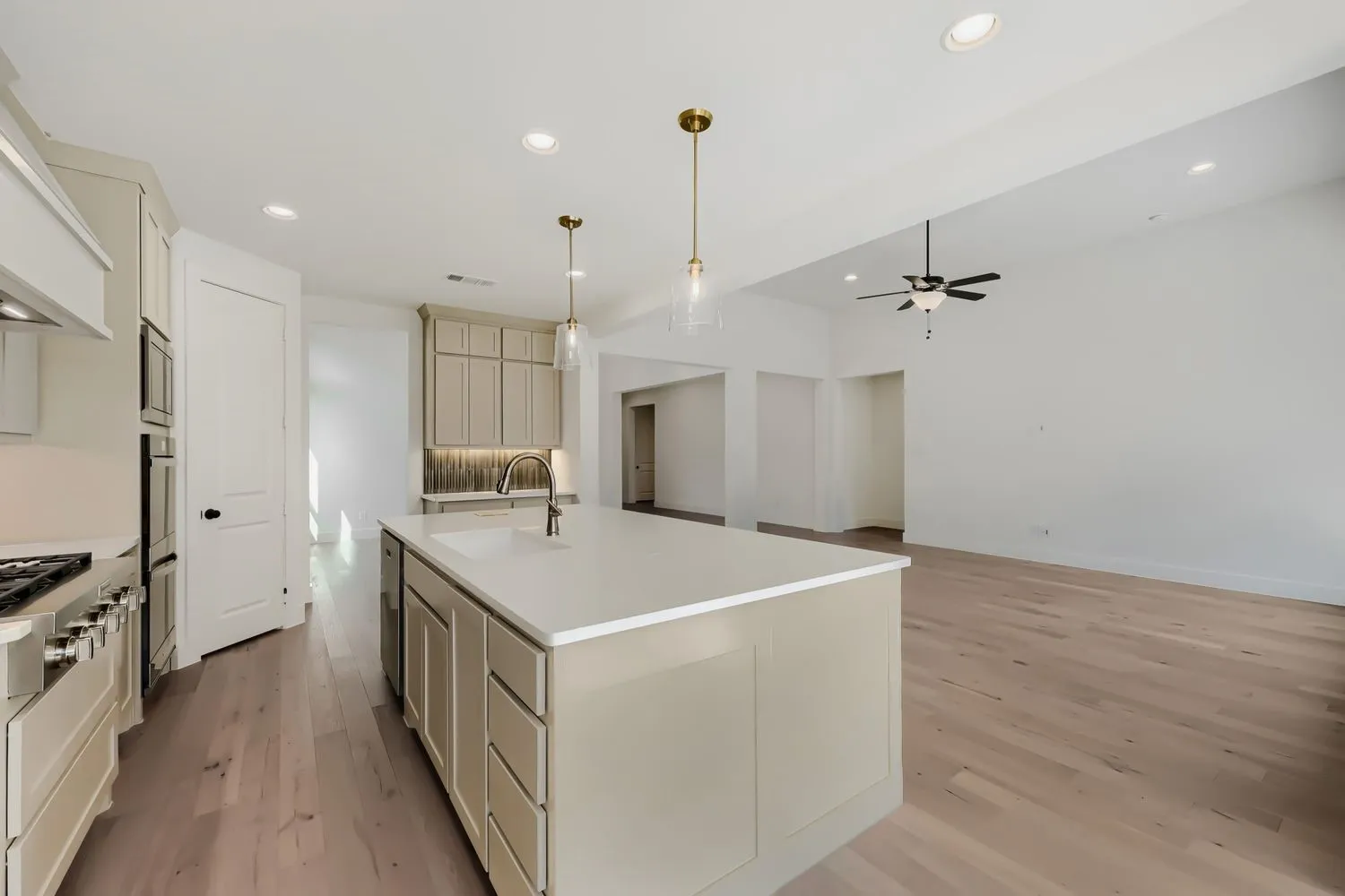 Spacious kitchen featuring a large island, stainless steel appliances, recessed lighting, and wood-finish flooring