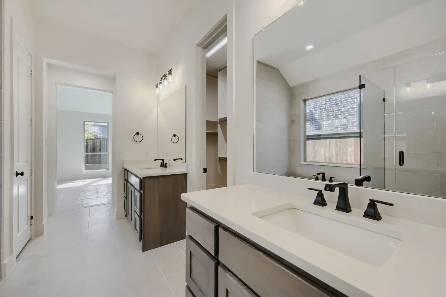Dual vanities with white countertops and undermount sinks