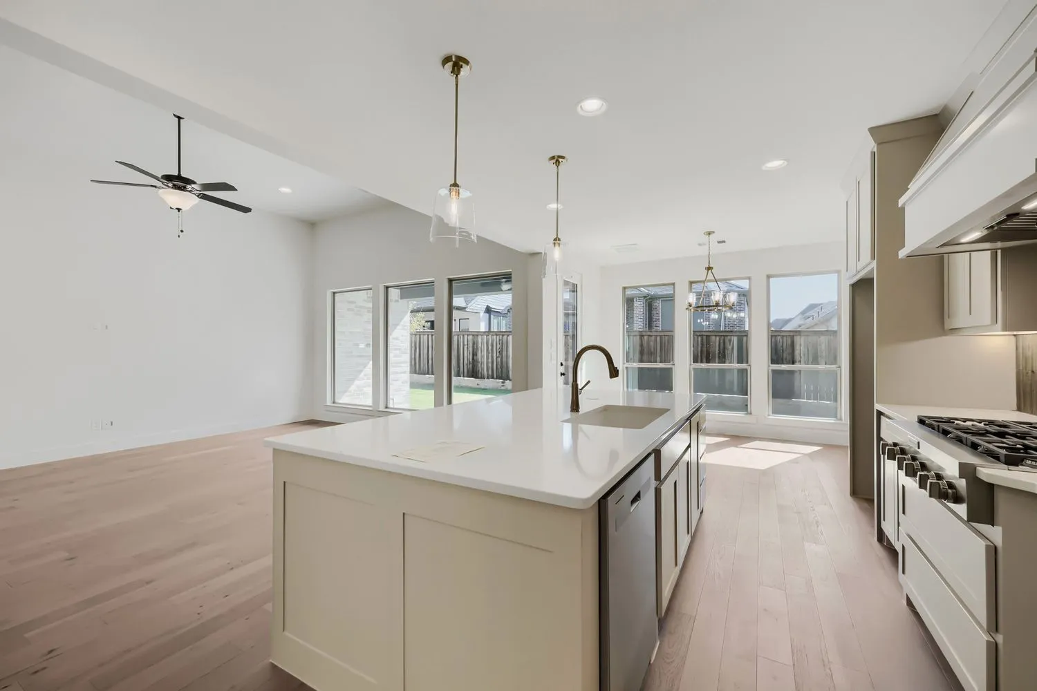 Open-concept kitchen with a large island, stainless steel appliances, and abundant natural light