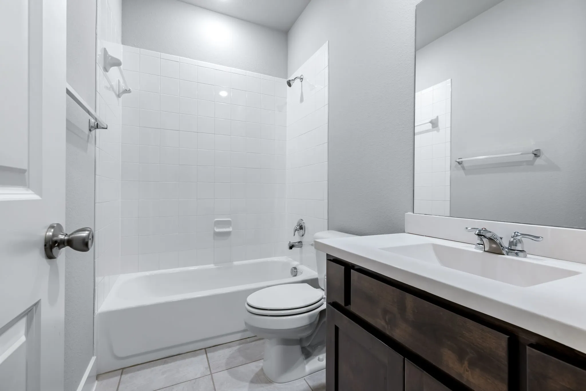 Bathroom featuring a single vanity with dark wood-finish cabinetry, an integrated sink, and a chrome faucet
