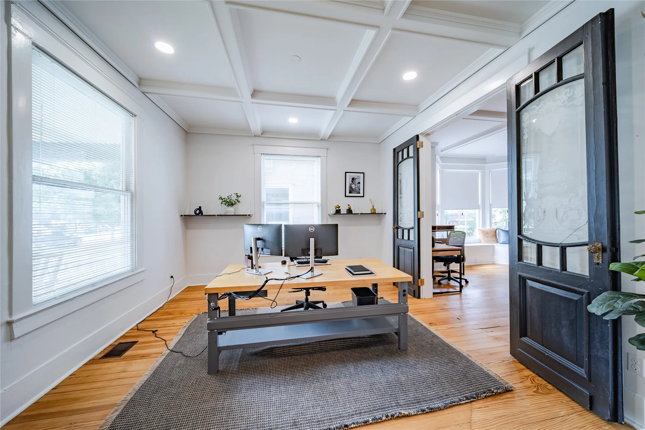Looking into the front office to the left of the entrance office. This office has views to the front porch and connects to the third office on the first level. Each office features functioning doors for privacy.