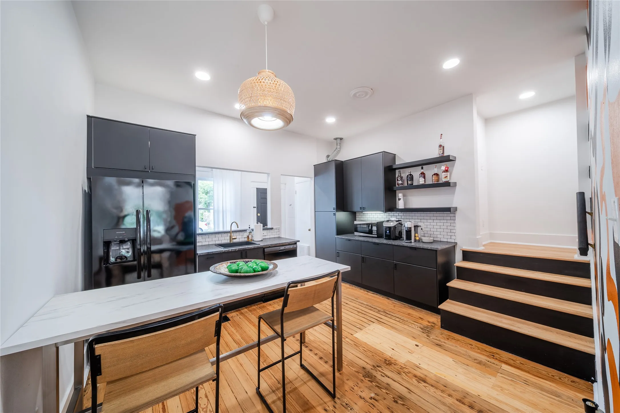 The kitchen on the first level is located in the back of the building. The stairs in the photo lead to the second level.