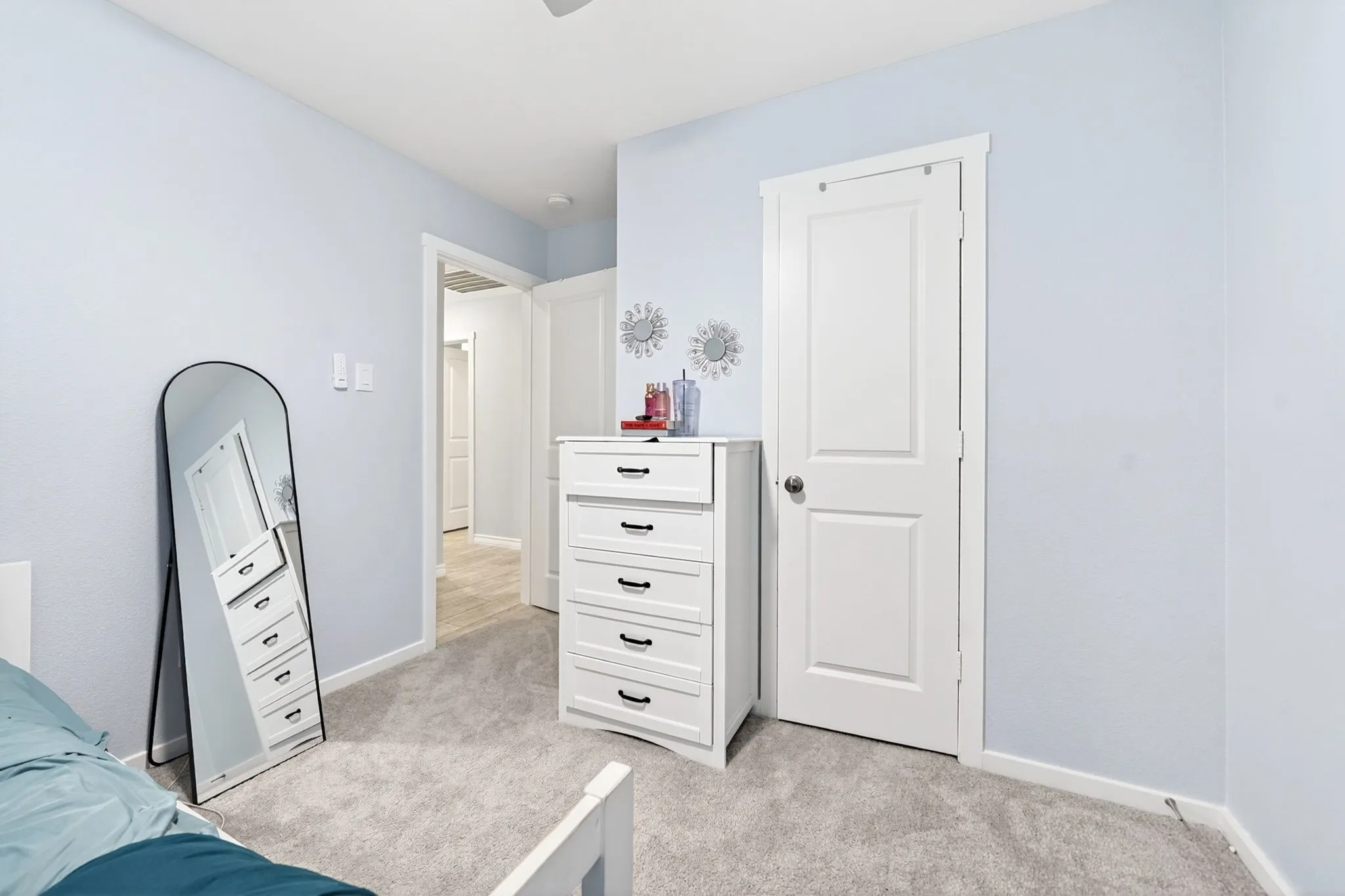 Carpeted room with light blue walls and a white paneled door