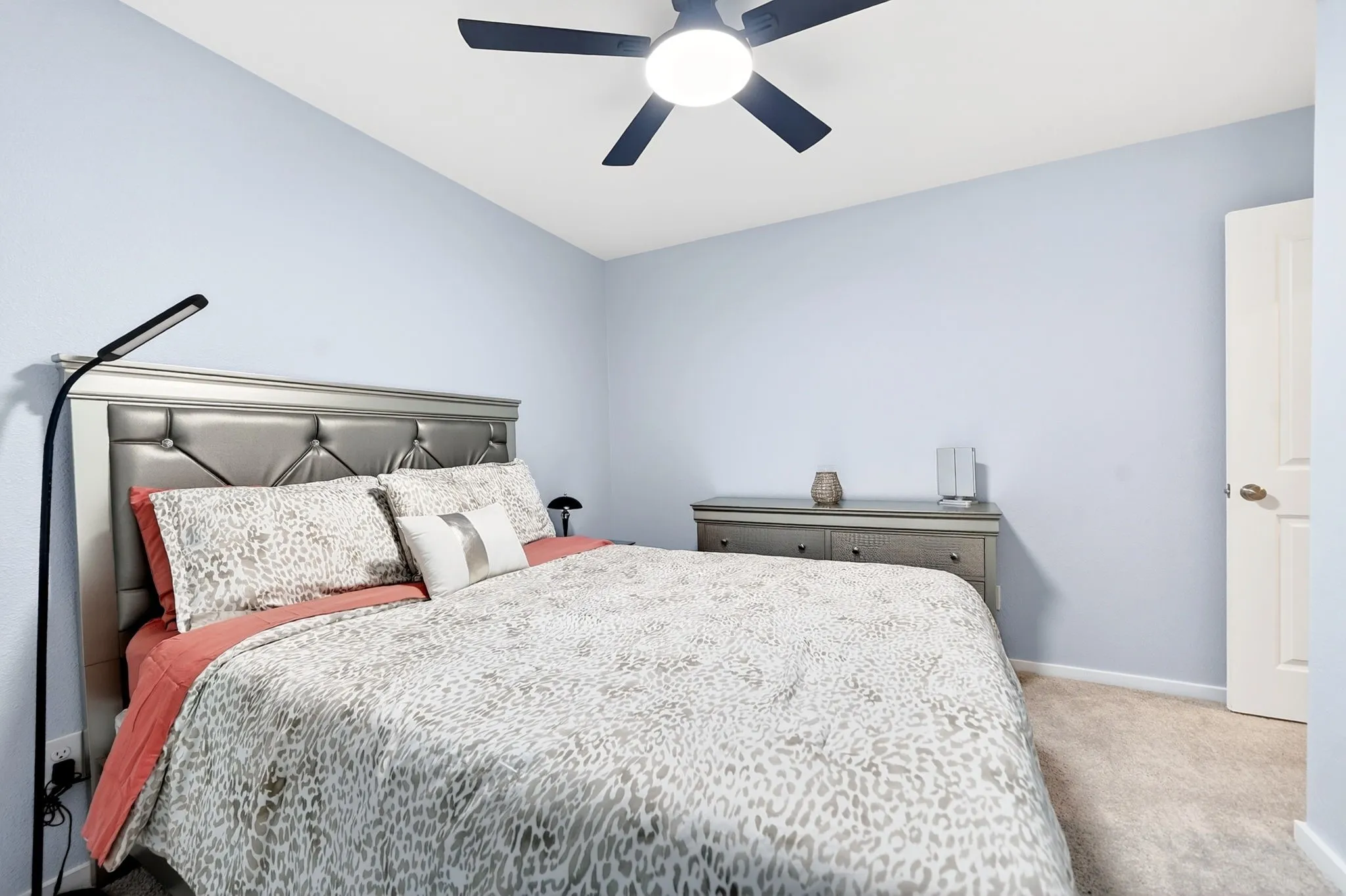 Bedroom featuring light blue walls, a ceiling fan with integrated lighting, and carpet flooring