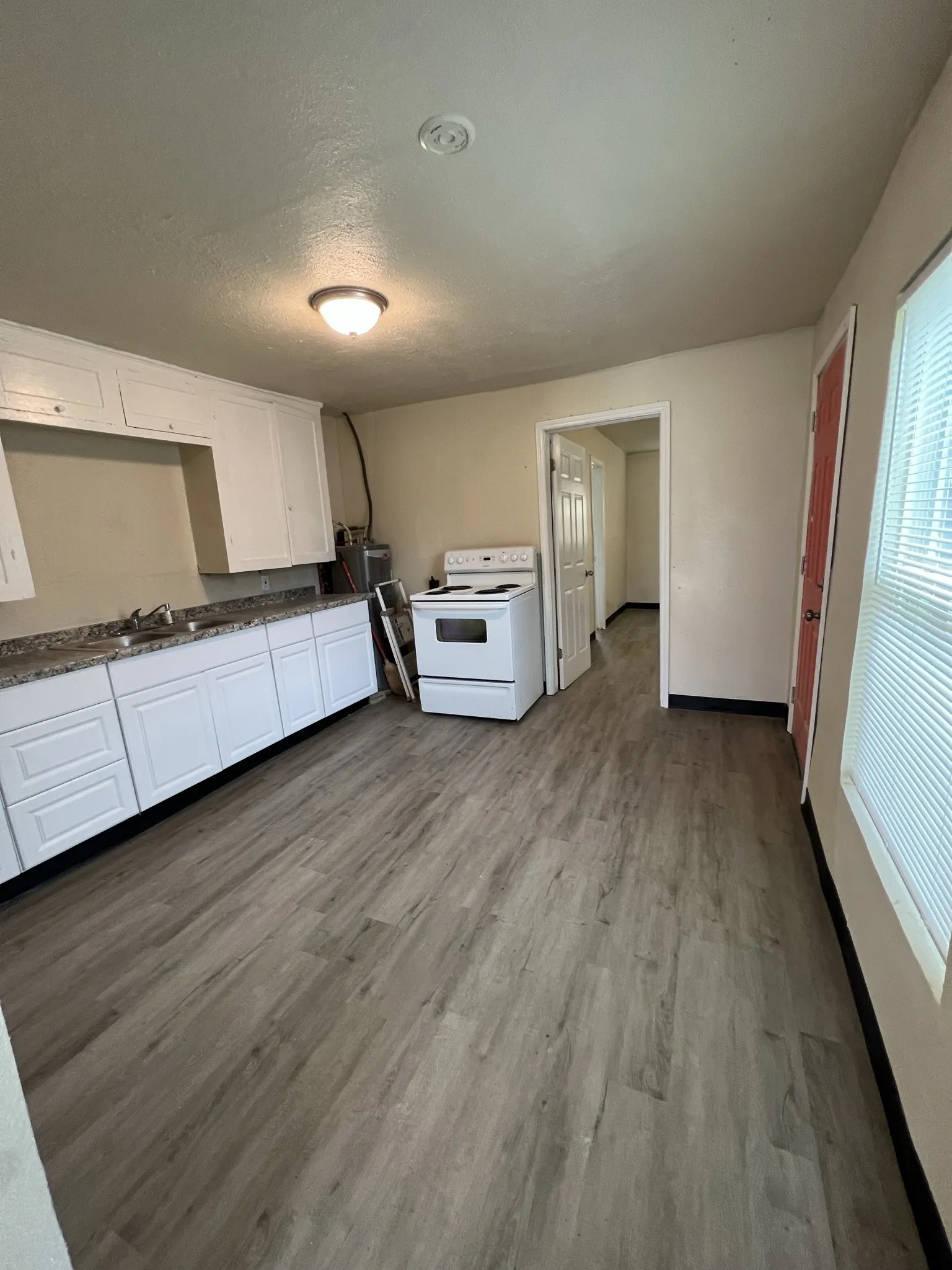 Kitchen featuring wood-finish flooring, white cabinetry, granite-style countertops, and a white electric range