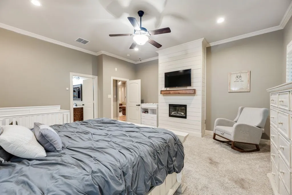 Primary Suite fully carpeted with recessed lighting and a ceiling fan and fireplace for ambiance