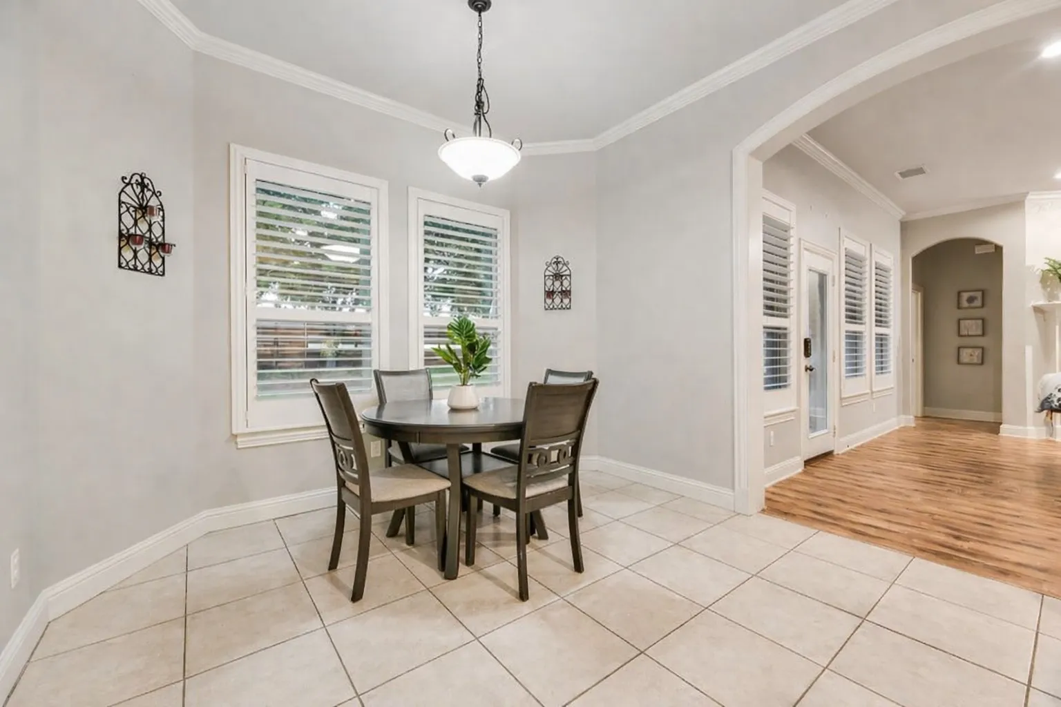 Dining area featuring neutral wall paint, crown molding, and a drum-style ceiling light