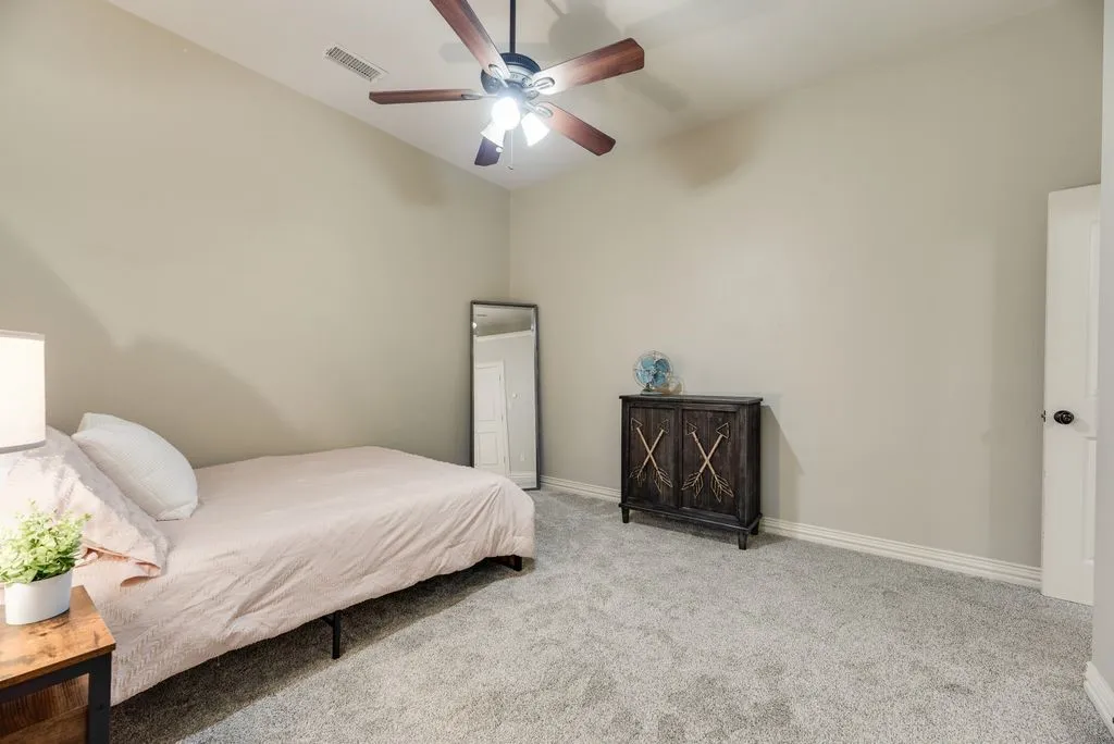 Bedroom 3: featuring a vaulted ceiling with a ceiling fan, light gray wall paint, and soft gray carpeting