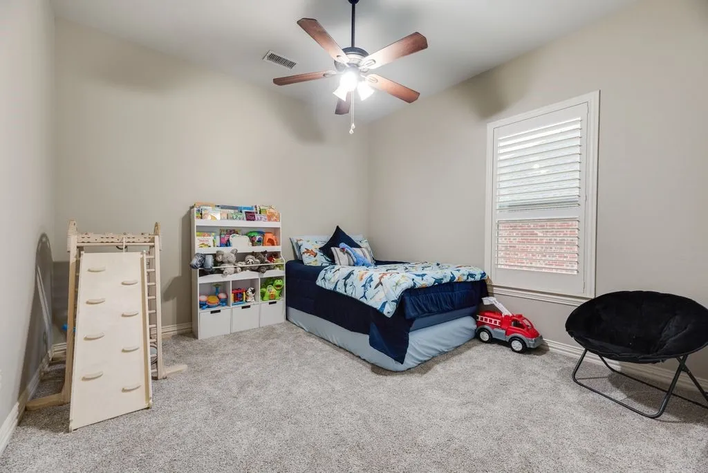 Bedroom 2: Carpeted Queen-sized bedroom with a ceiling fan with light fixture