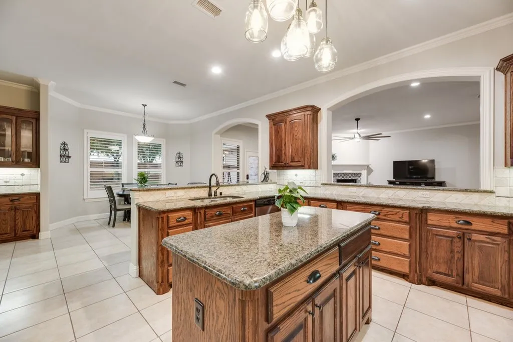 Kitchen featuring a central island with granite countertops, wood cabinetry, and tile flooring