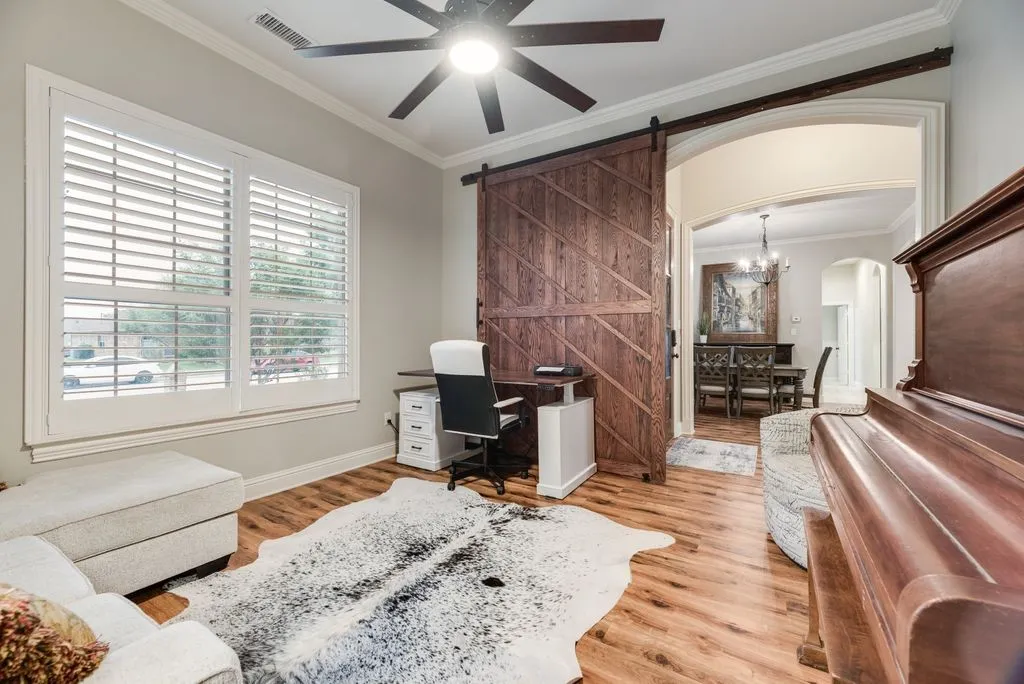 Office featuring wood-finish flooring, a ceiling fan, and crown molding
