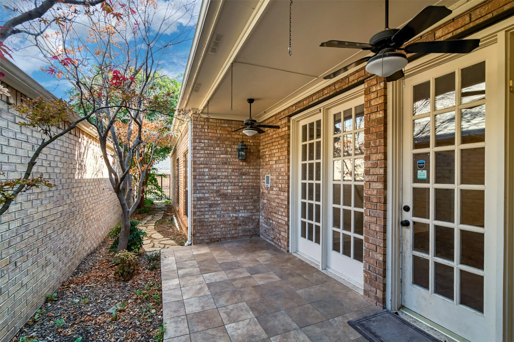 Covered patio featuring tiled flooring and dual ceiling fans