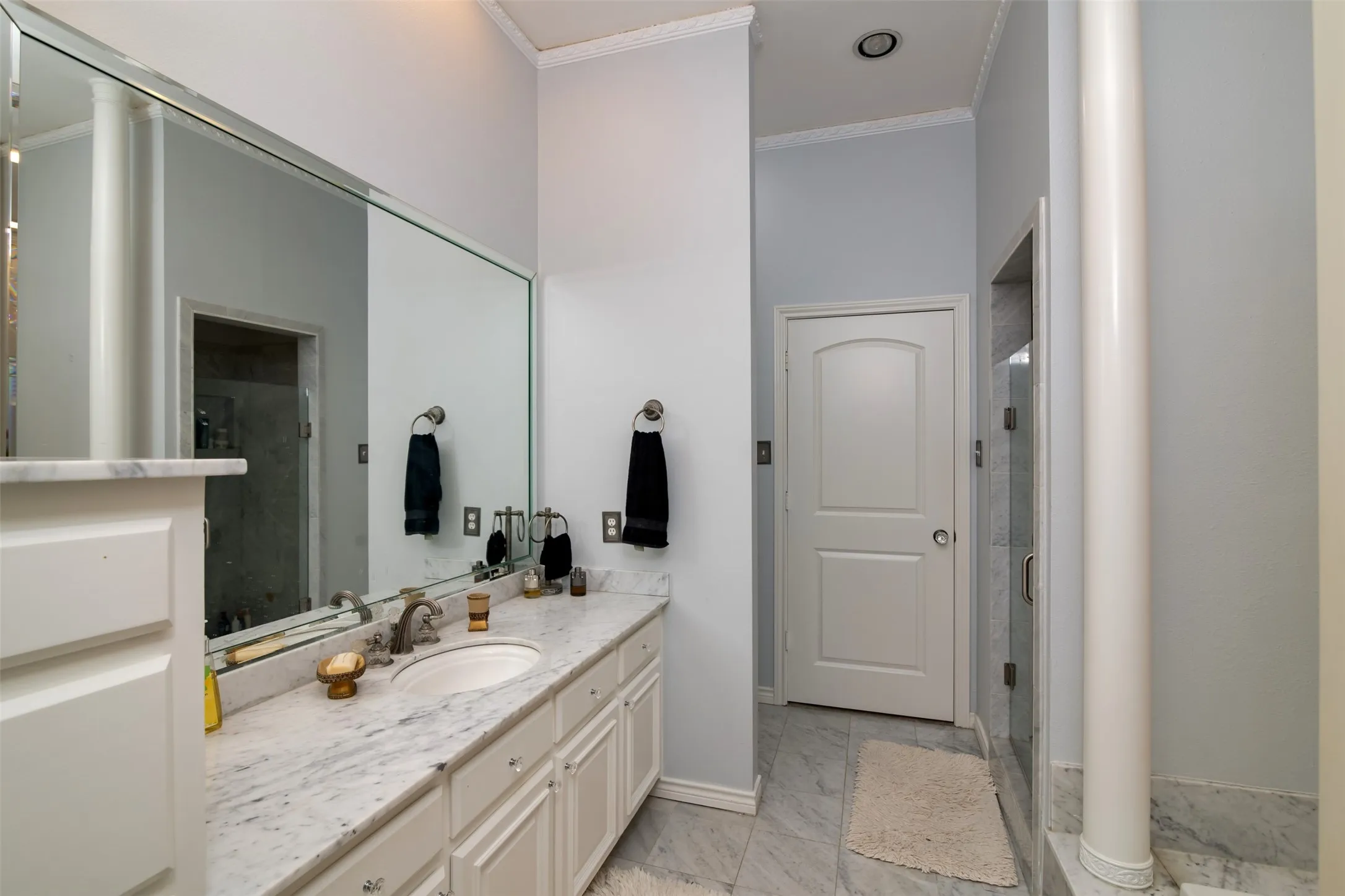 Bathroom vanity featuring a light-colored countertop with an undermount sink and a large wall-mounted mirror