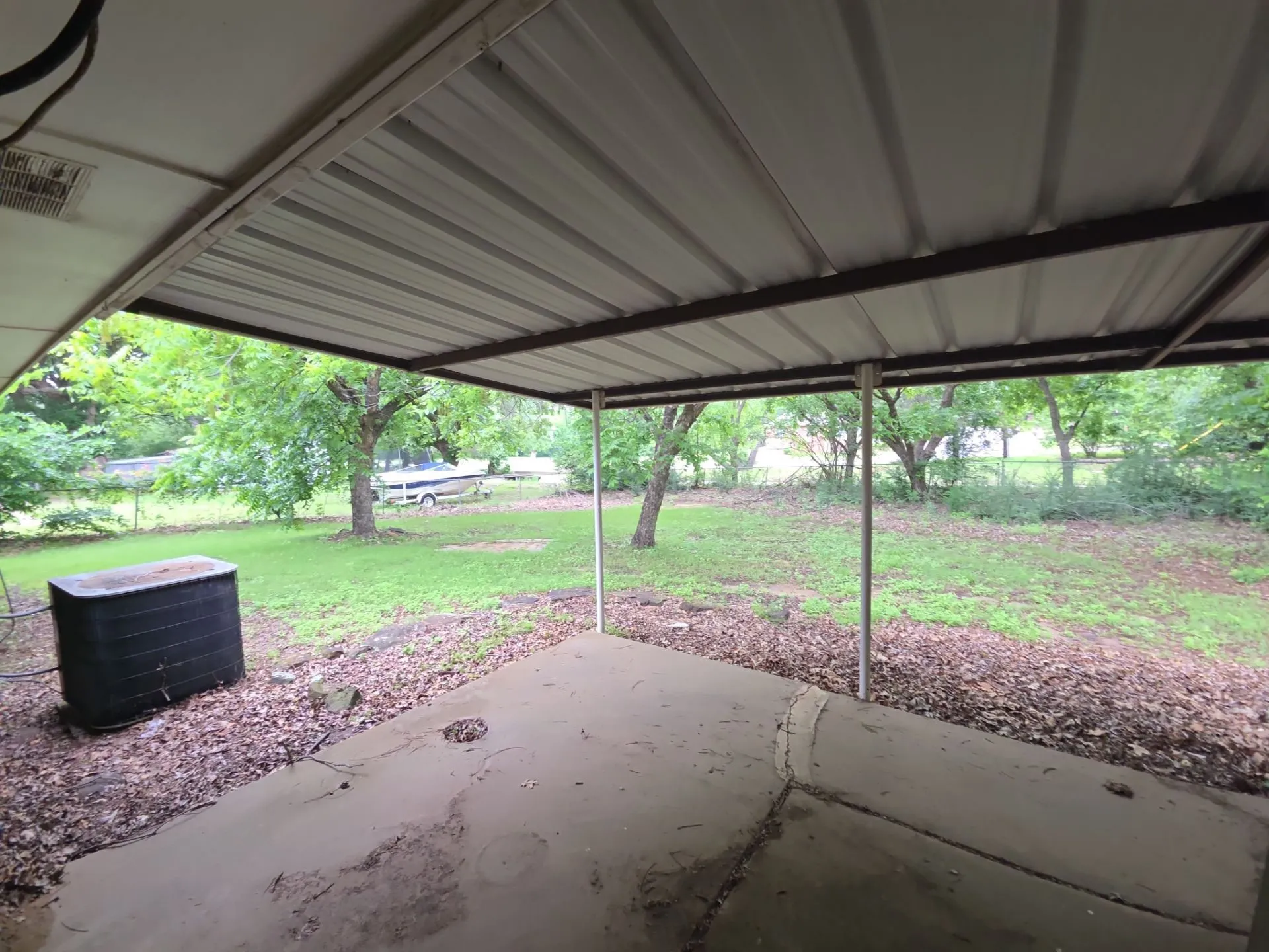 Covered patio with a concrete slab, metal roofing, and multiple support posts