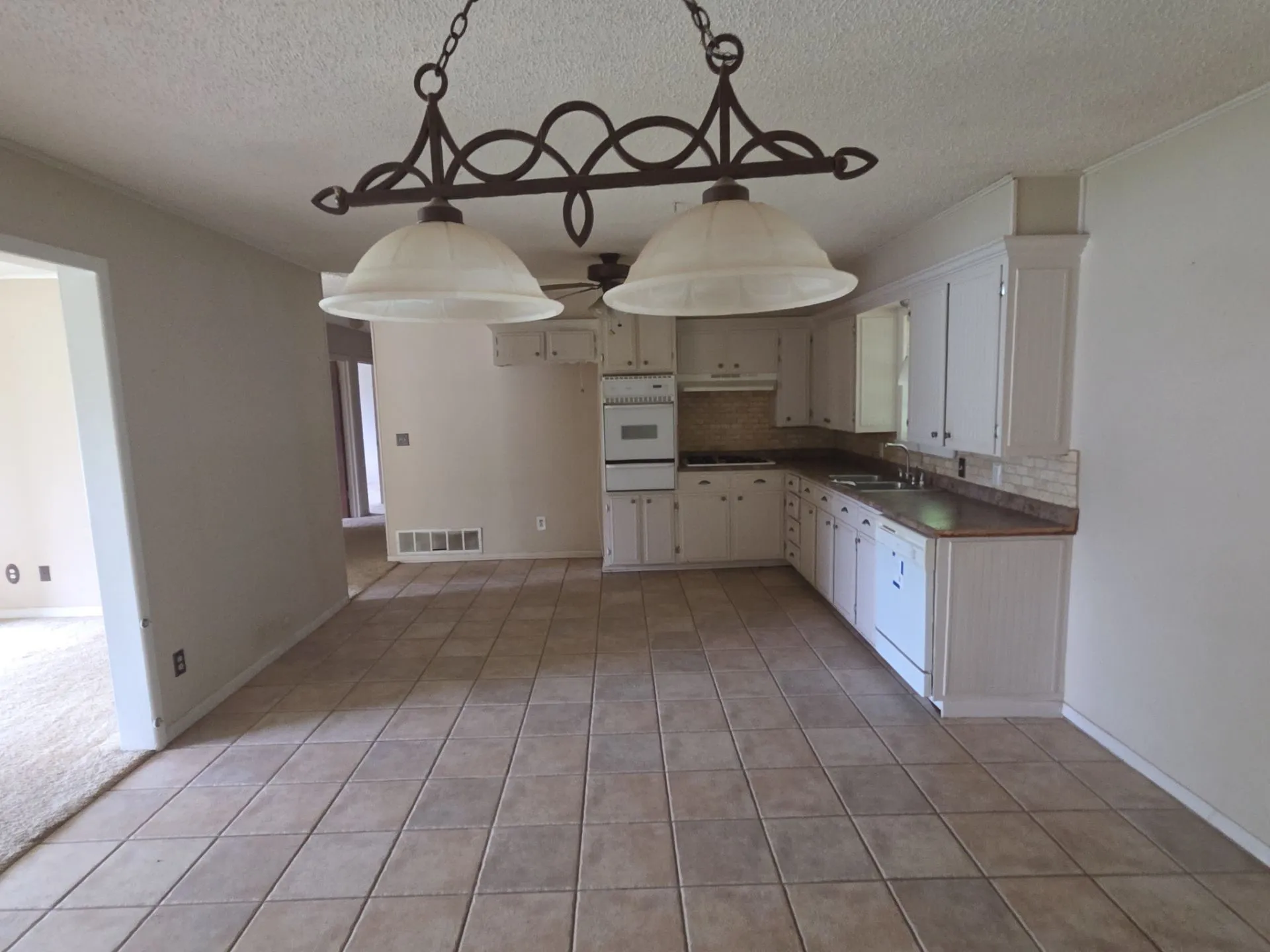 Kitchen area featuring white cabinetry, a built-in oven, and a tiled backsplash