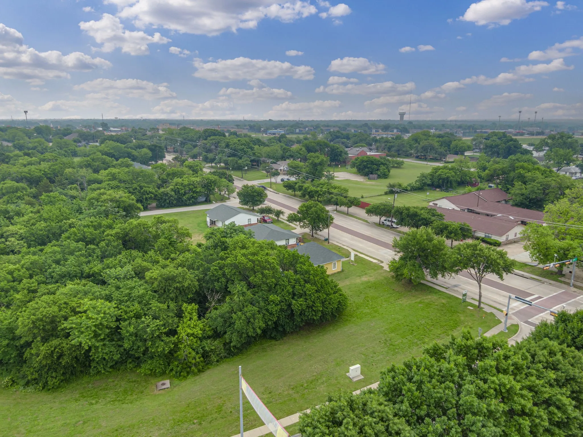 Aerial perspective showcasing a residential area with extensive tree coverage