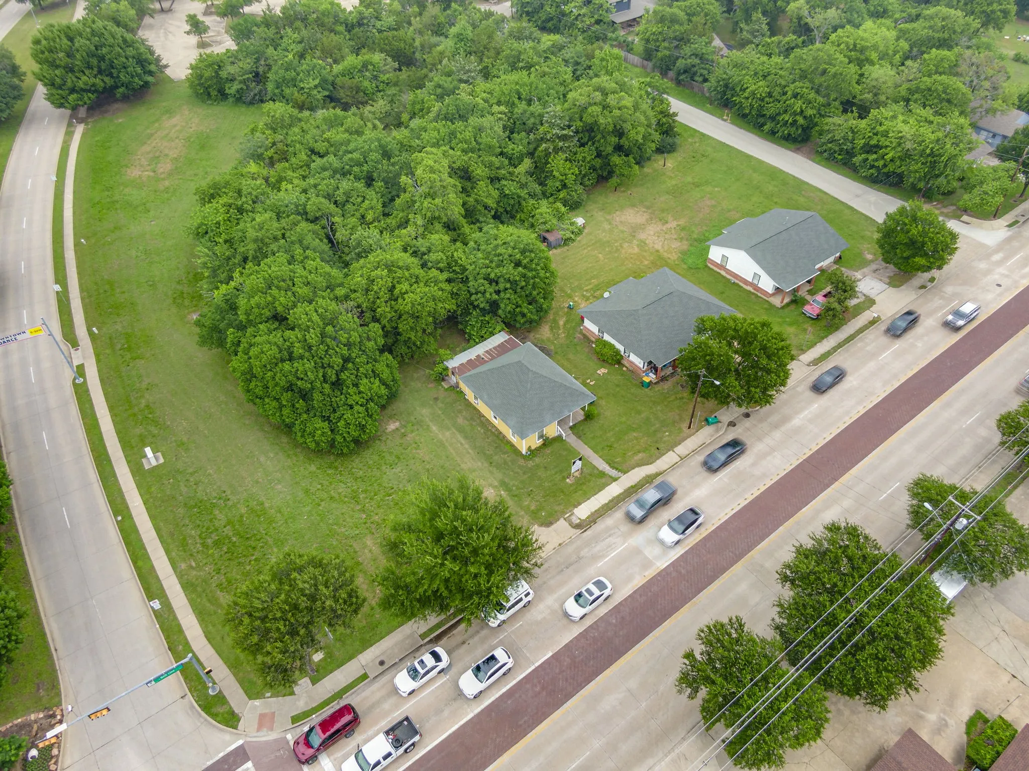 Expansive corner lot featuring mature trees and a substantial grassy area