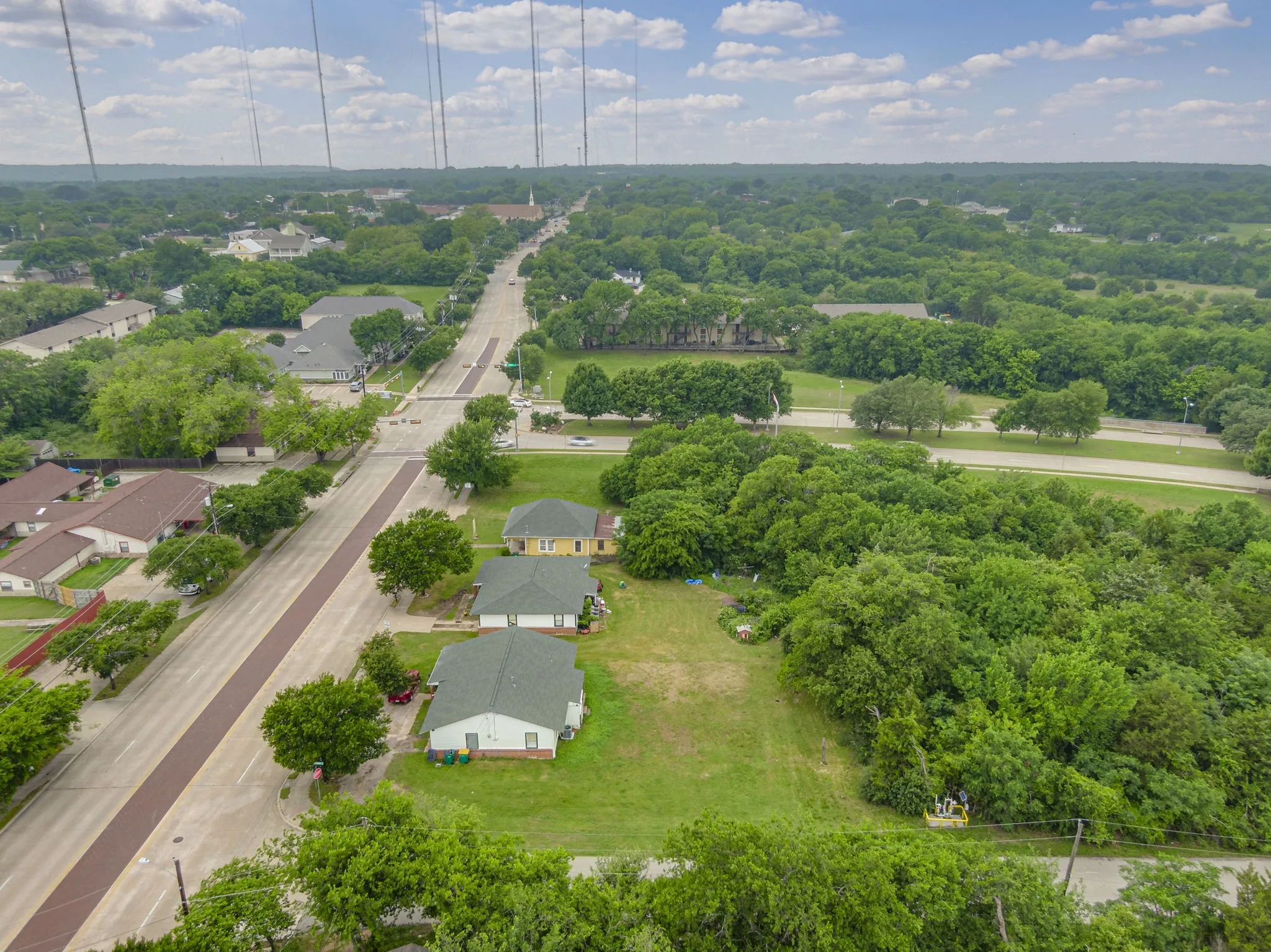 Aerial perspective showcasing a residential area bordered by lush greenery