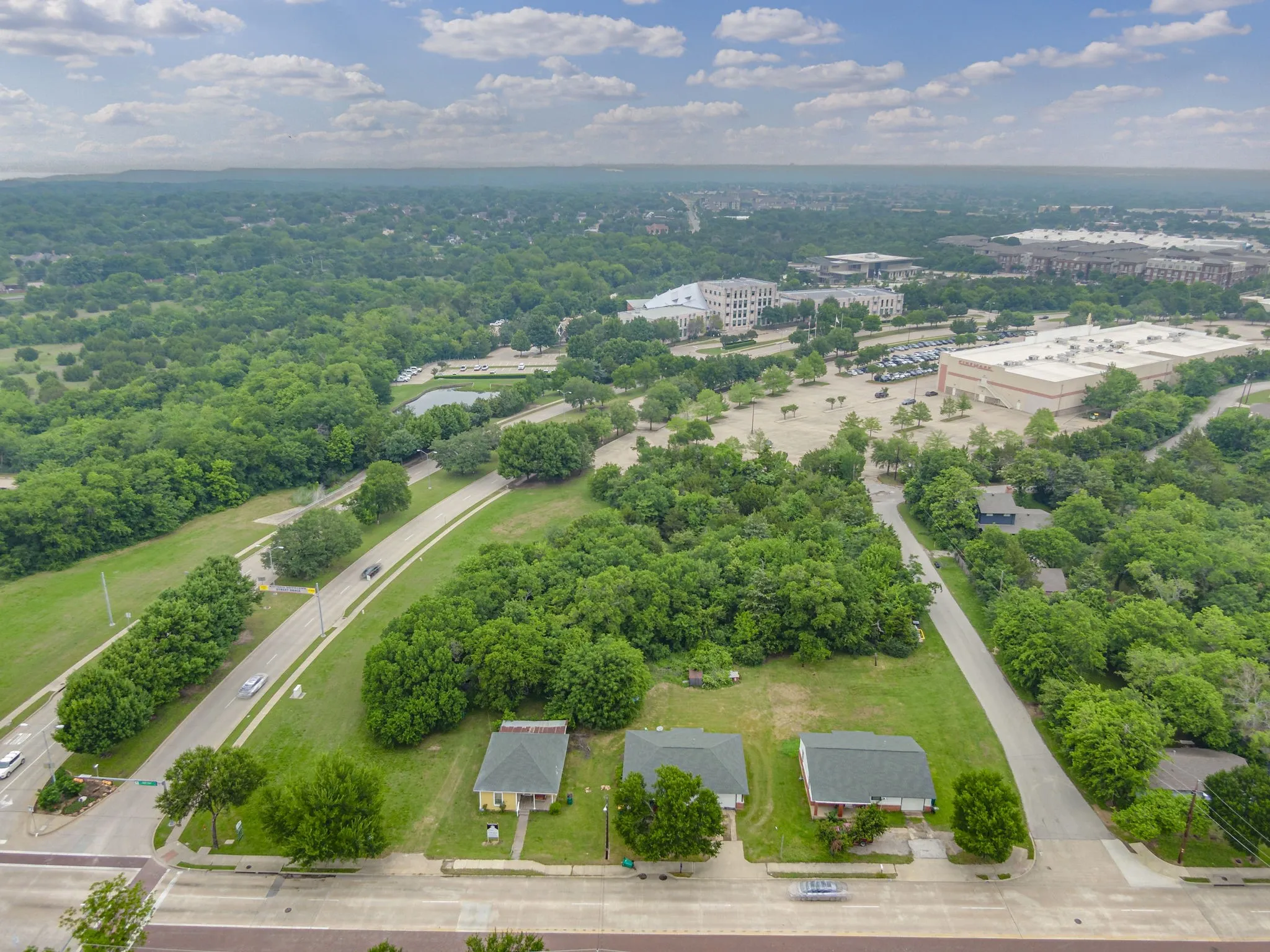 Aerial perspective showcasing three properties situated along a paved road