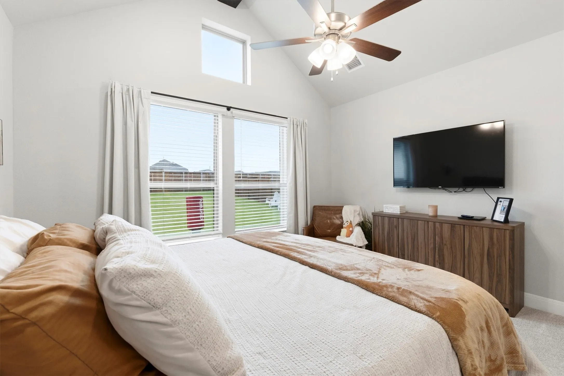 Primary bedroom with ceiling fan and a transom window for natural light