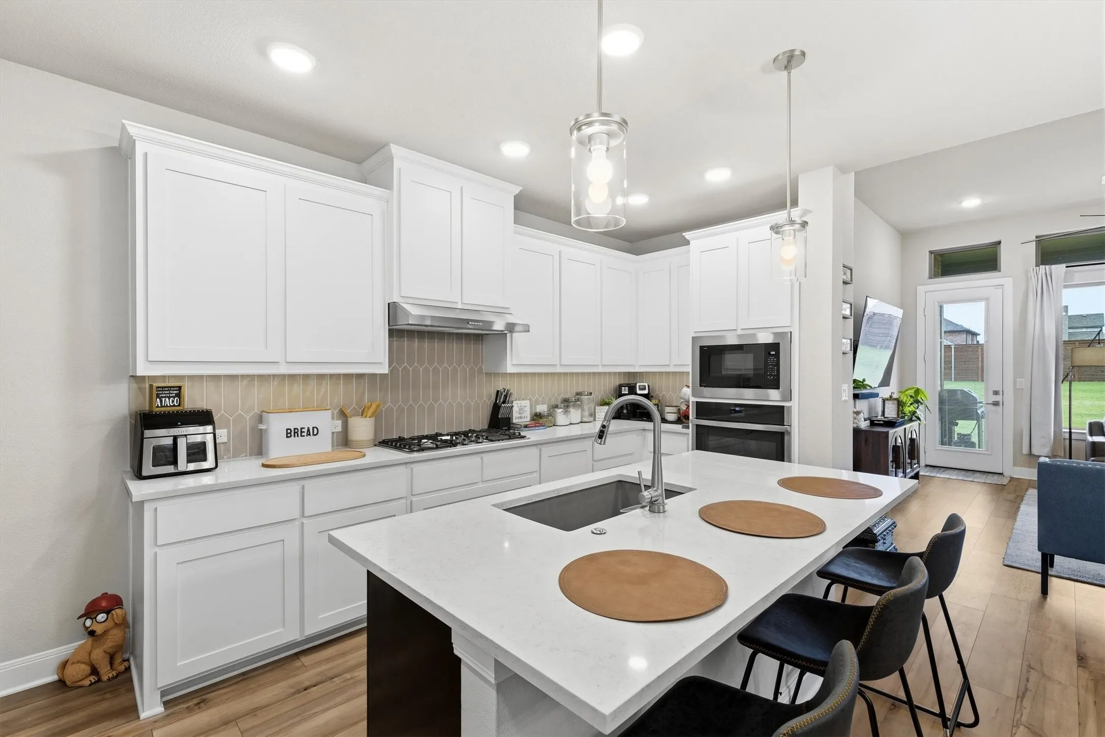 A wall mounted oven, gas cooktop and extra seating in the kitchen