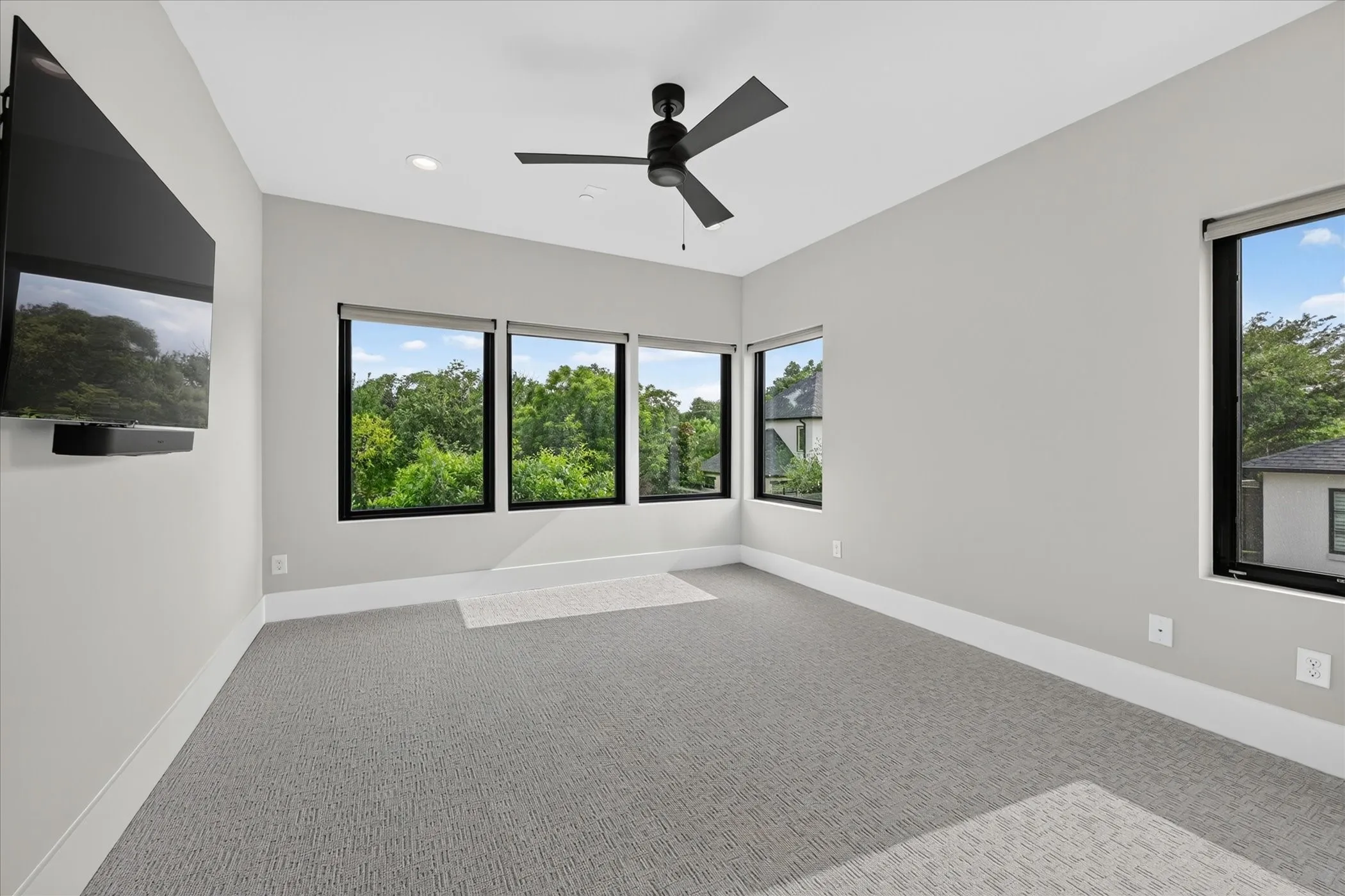 Room featuring multiple windows with black trim, recessed lighting, and a dark-toned ceiling fan