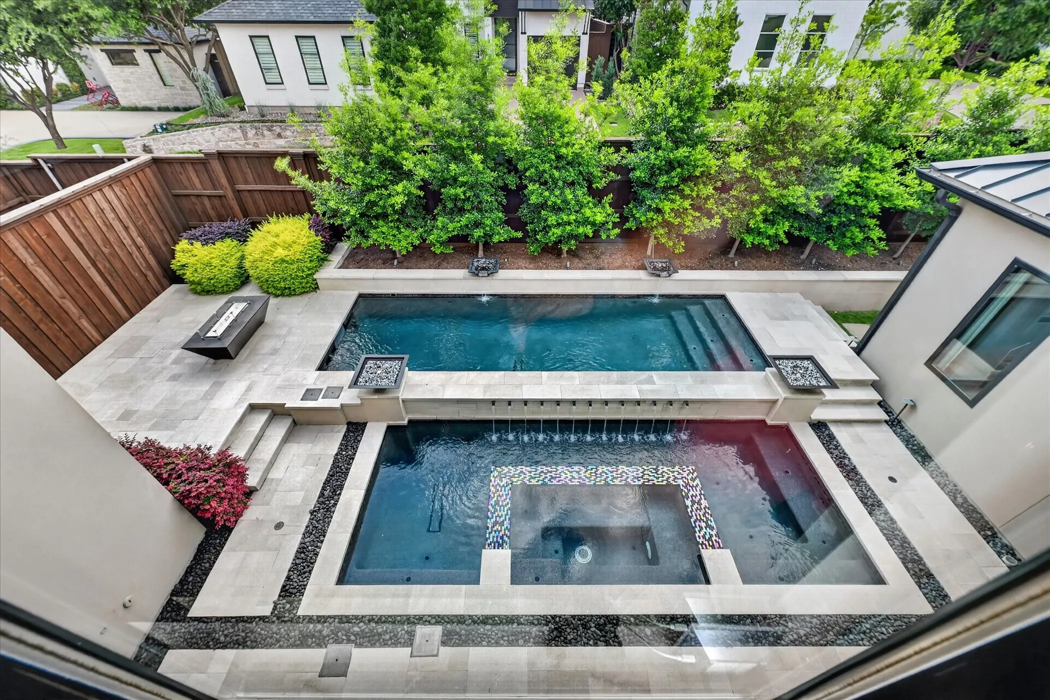 Resort-style backyard featuring a multi-level pool with integrated water features and a spa