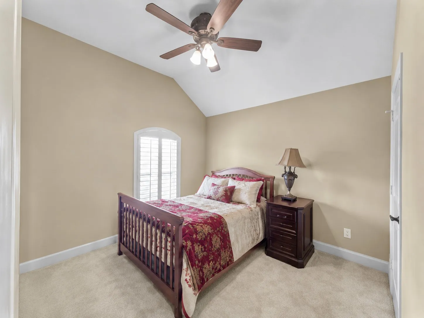 Bedroom 3, Vaulted ceiling, ceiling fan, arched window, plantation shutters, and carpeted flooring