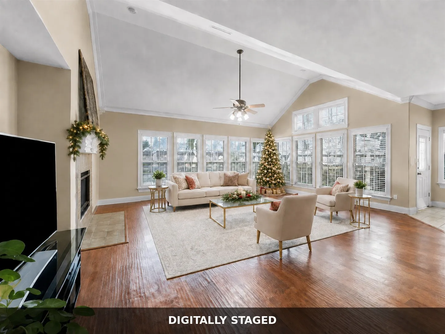 Vaulted ceiling, ceiling fan, wood-finish flooring, fireplace with mantel, and extensive window array