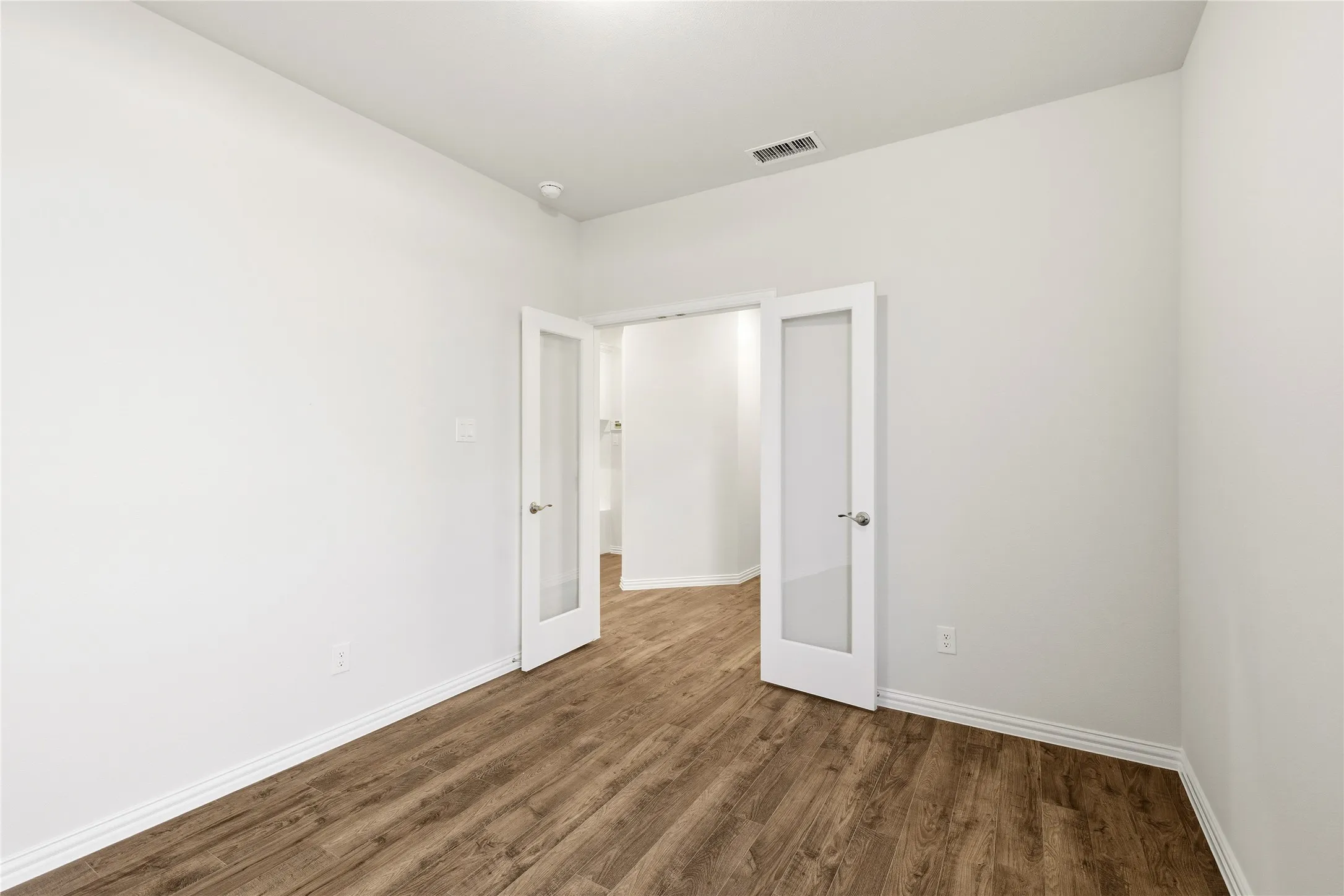 Office with wood laminate flooring.