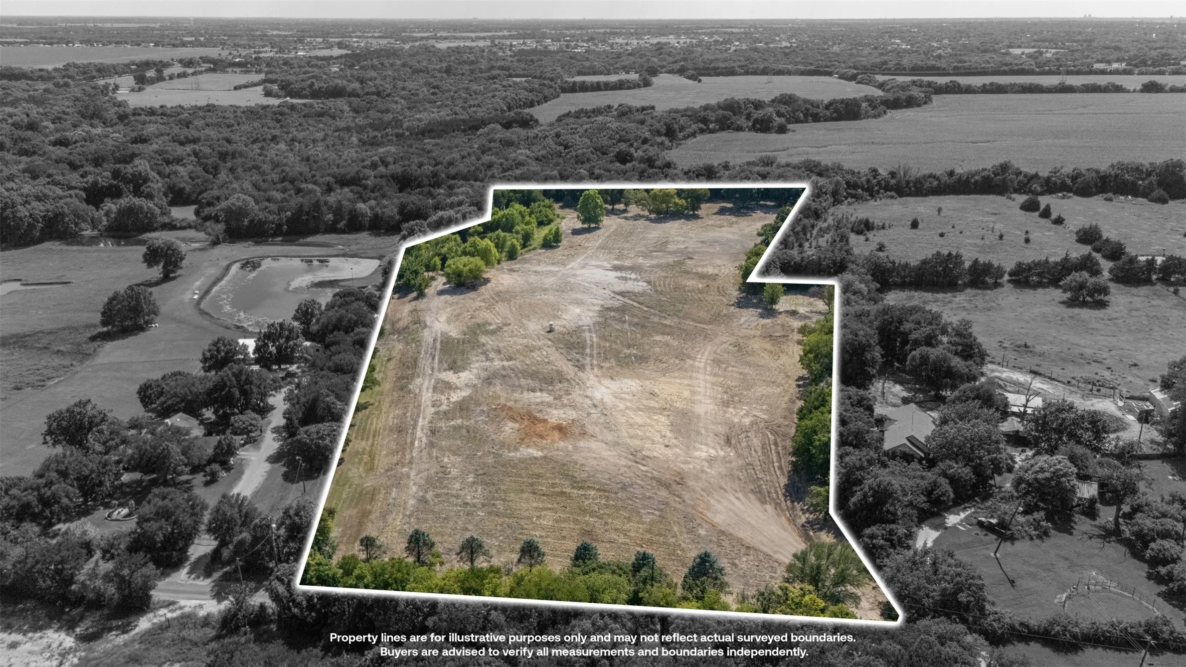 Expansive land parcel featuring a perimeter of mature trees, a clear central area, and a varied boundary line