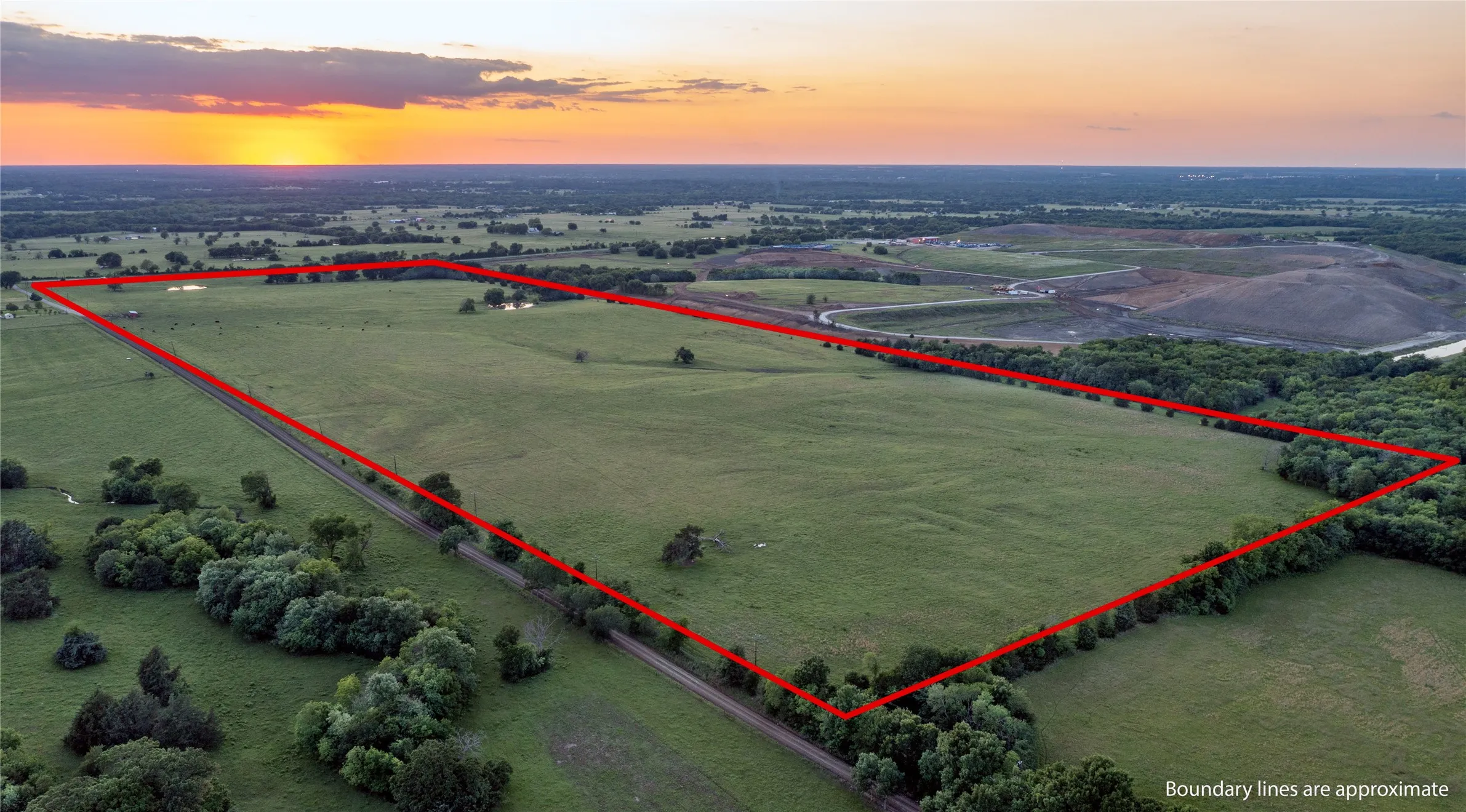 Expansive land parcel featuring open pastures and mature tree lines