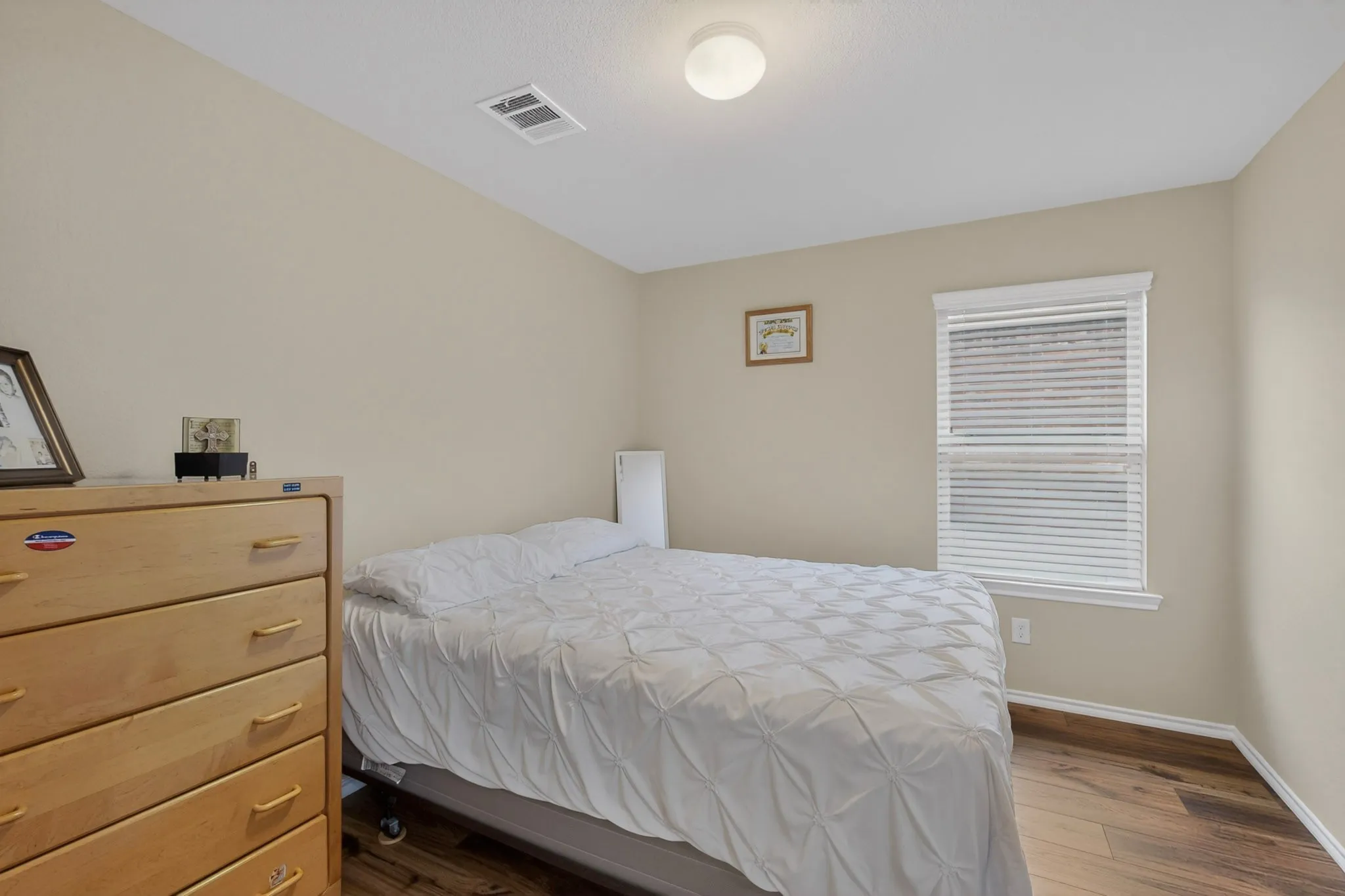 Neutral-toned walls complement the wood-finish flooring