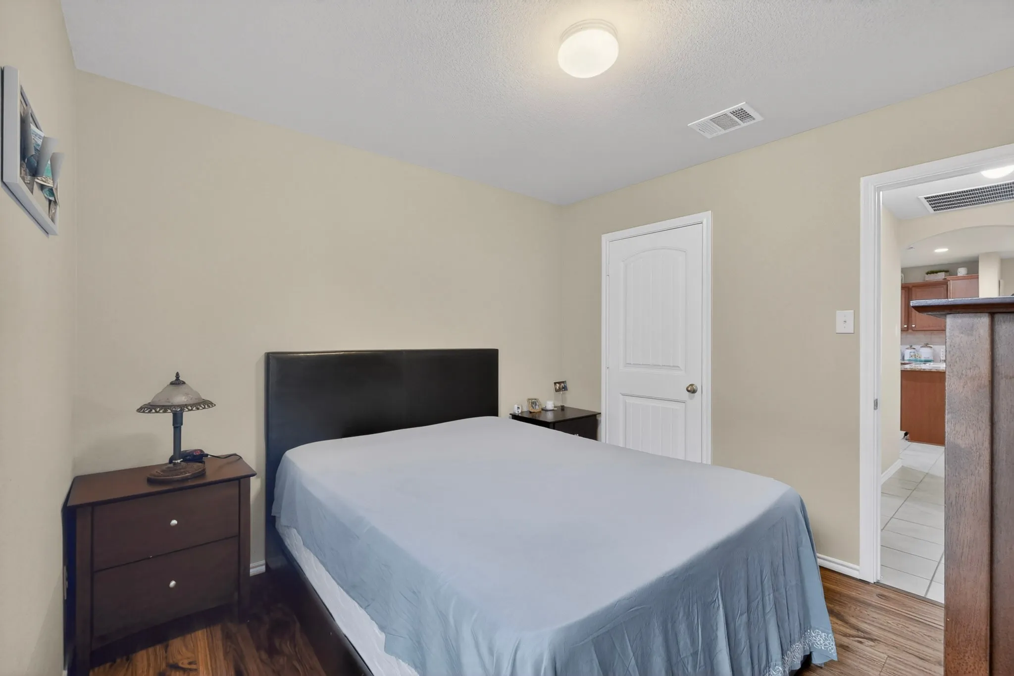 Warm interior space featuring wood-finish flooring, light beige wall paint, and a white paneled door