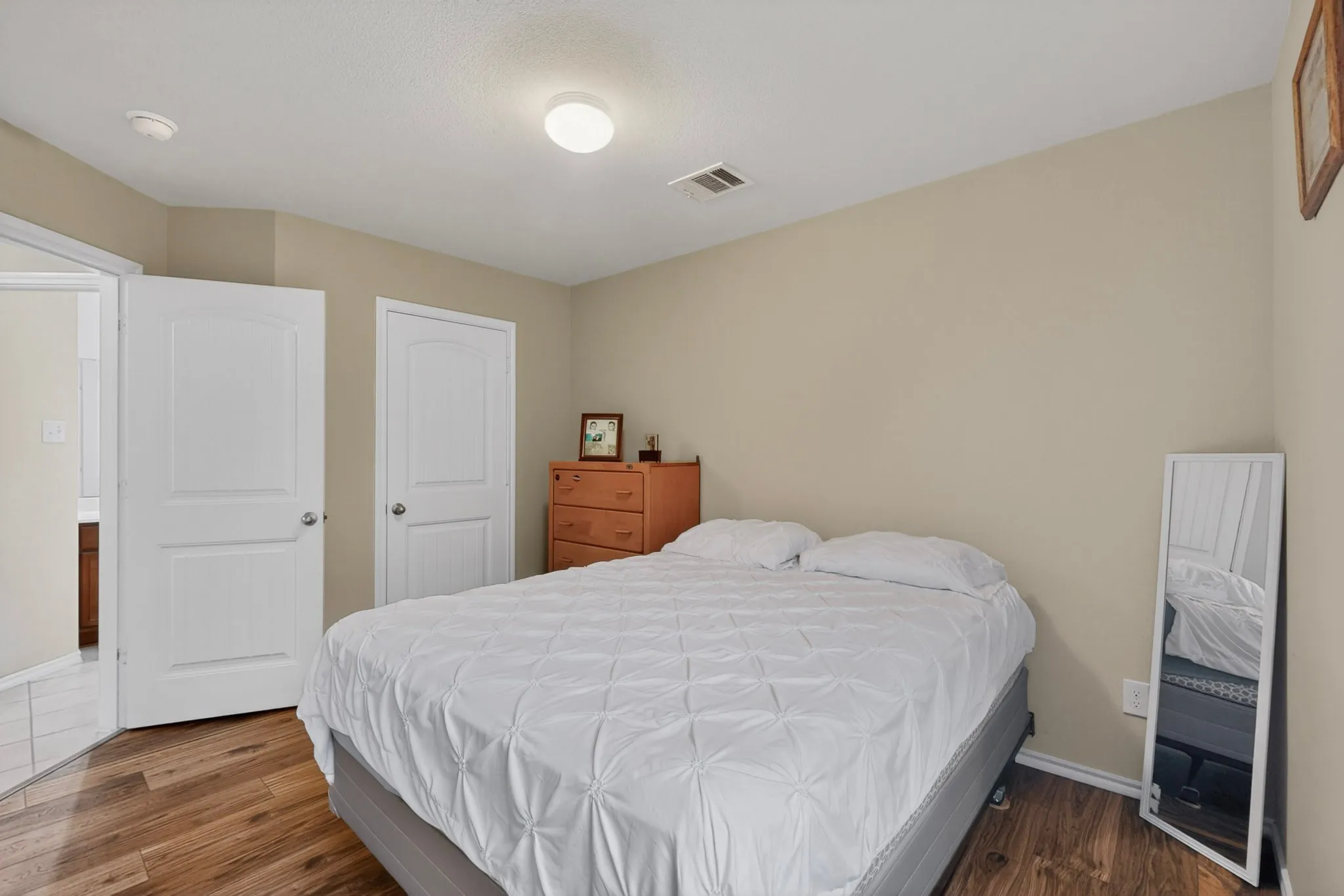 Bedroom featuring wood-finish flooring, two panel doors, and neutral wall paint