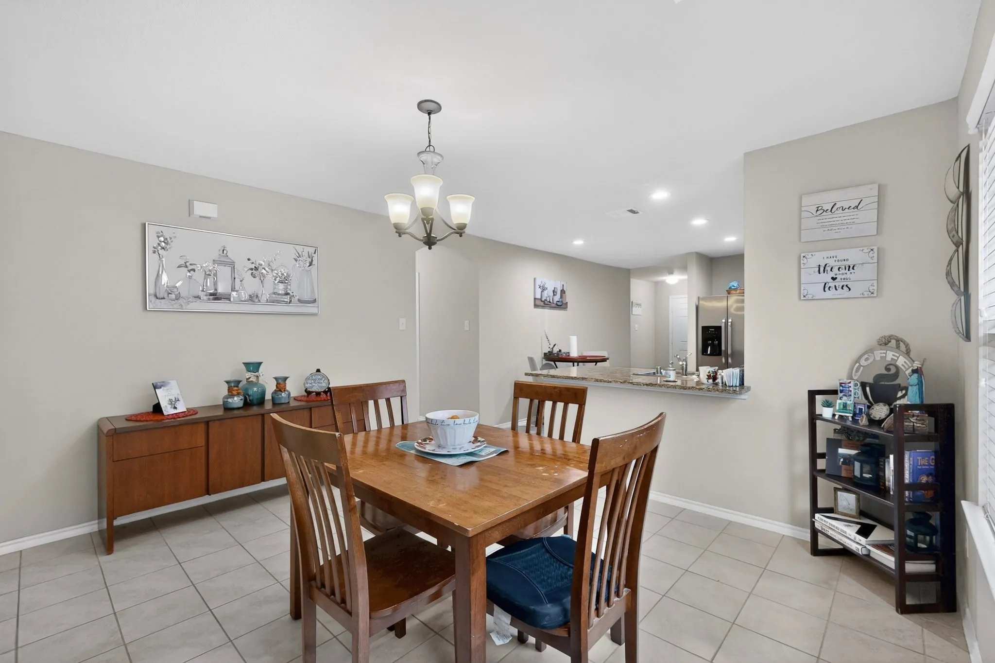 Open-concept dining area featuring neutral wall tones and tile flooring