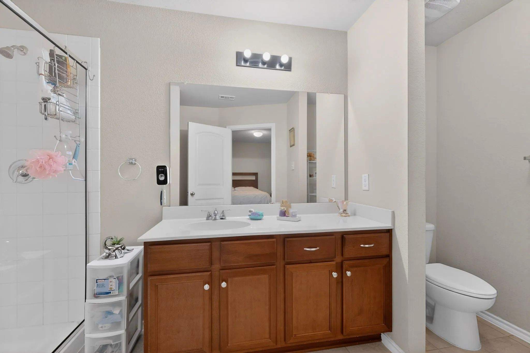 Bathroom featuring a single vanity with wood-finish cabinetry, a white countertop, and an integrated sink