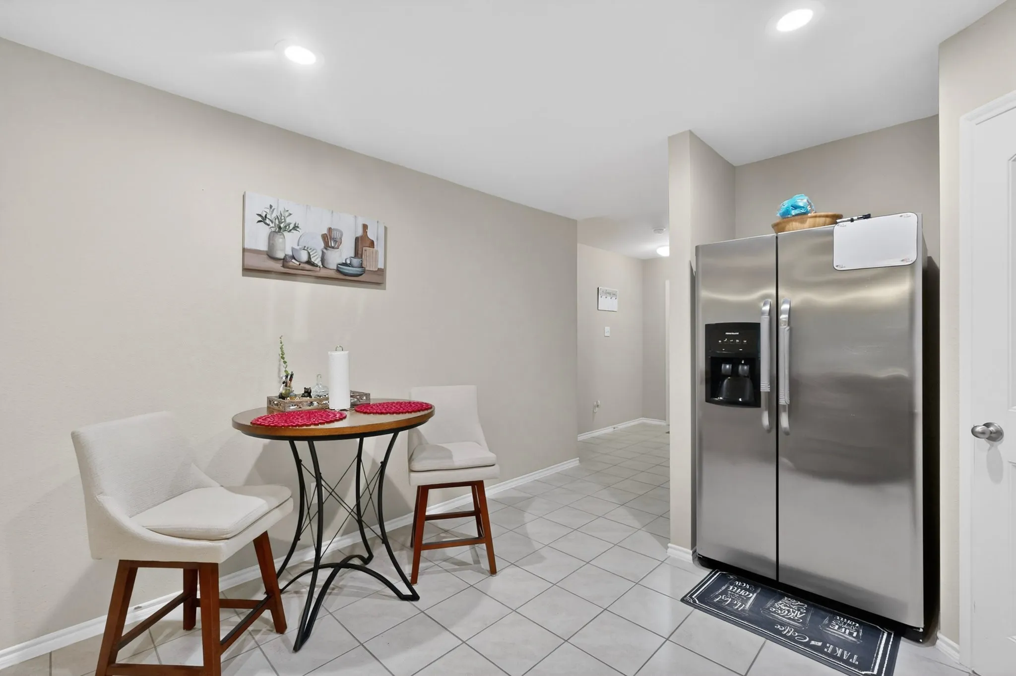 Kitchen area featuring tile flooring, recessed lighting, and a stainless steel side-by-side refrigerator