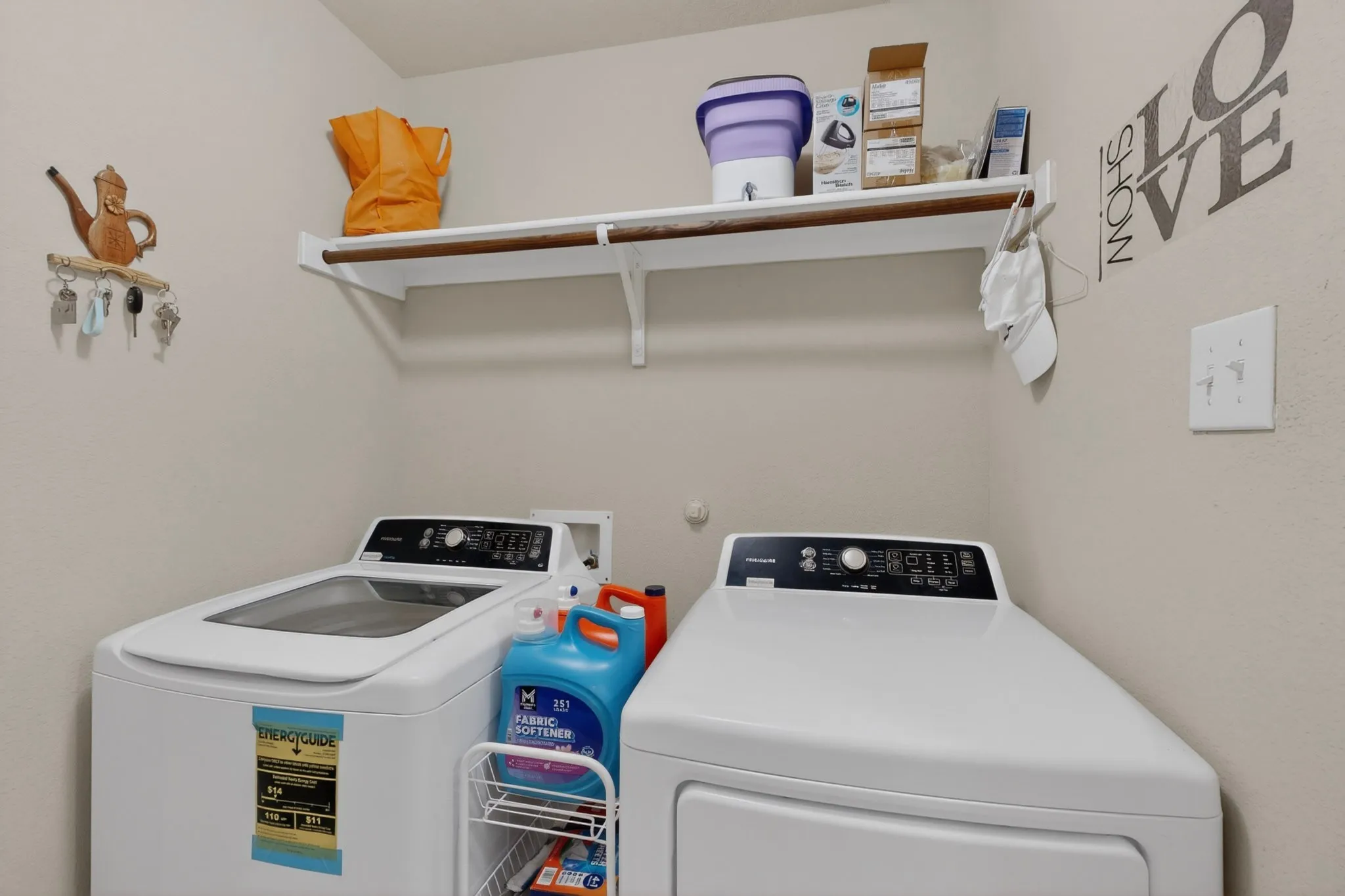 Dedicated laundry area featuring a white top-load washing machine and front-load dryer