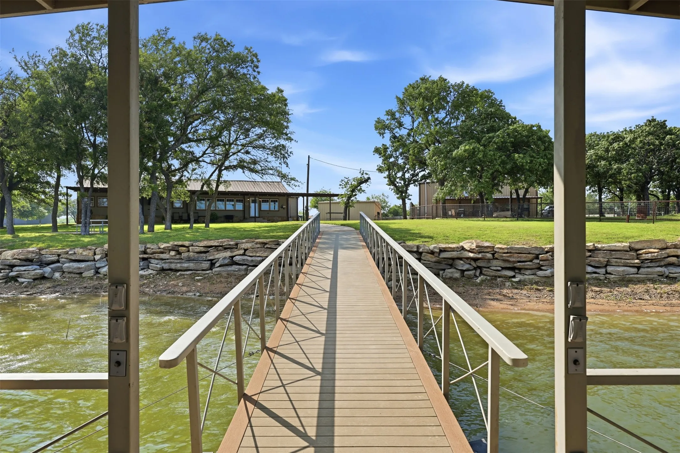 Dock system extending to the property, featuring composite decking and metal railings