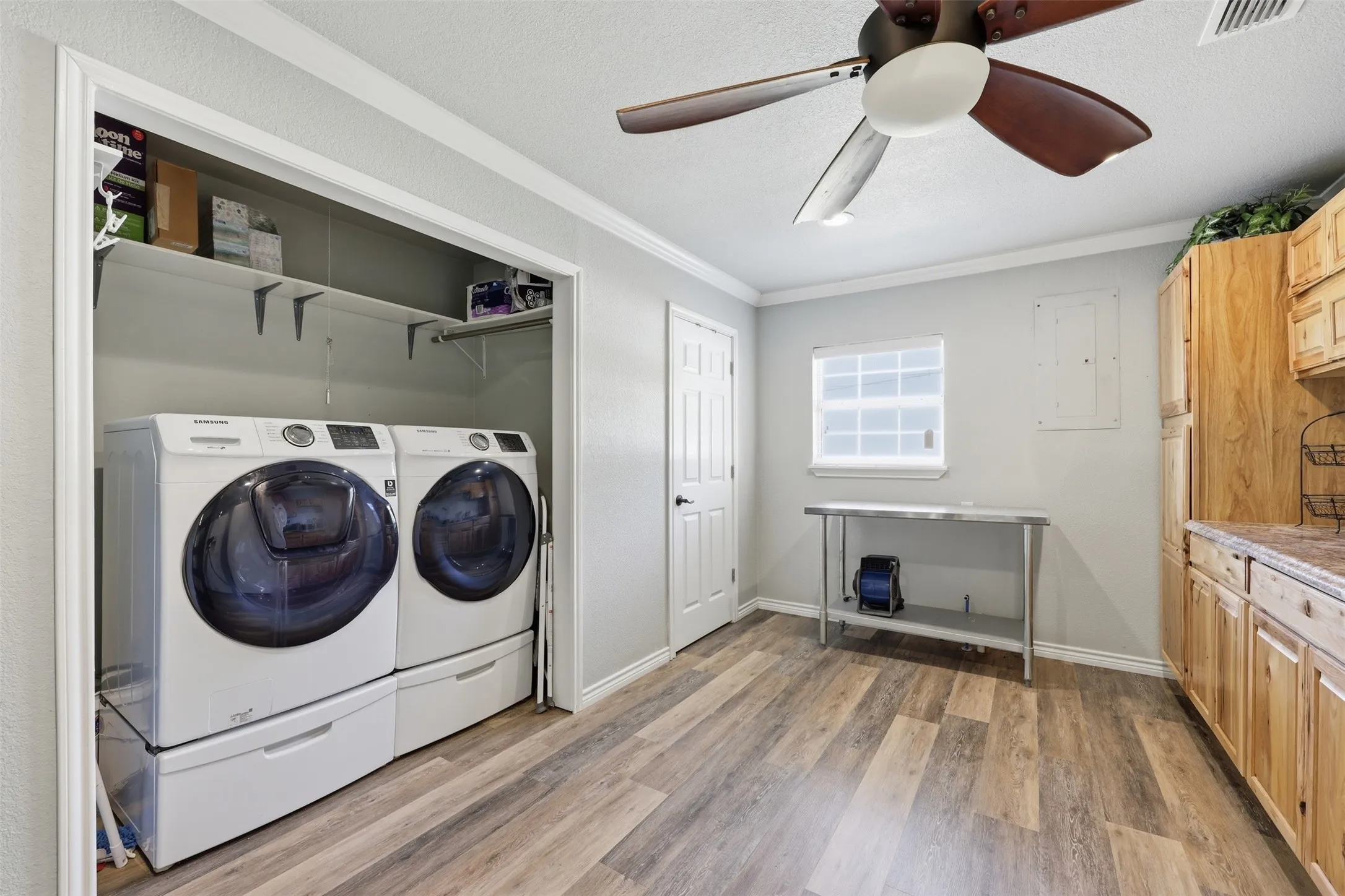 Dedicated laundry area featuring a built-in closet with shelving, wire racking and additional spatious wood cabinets