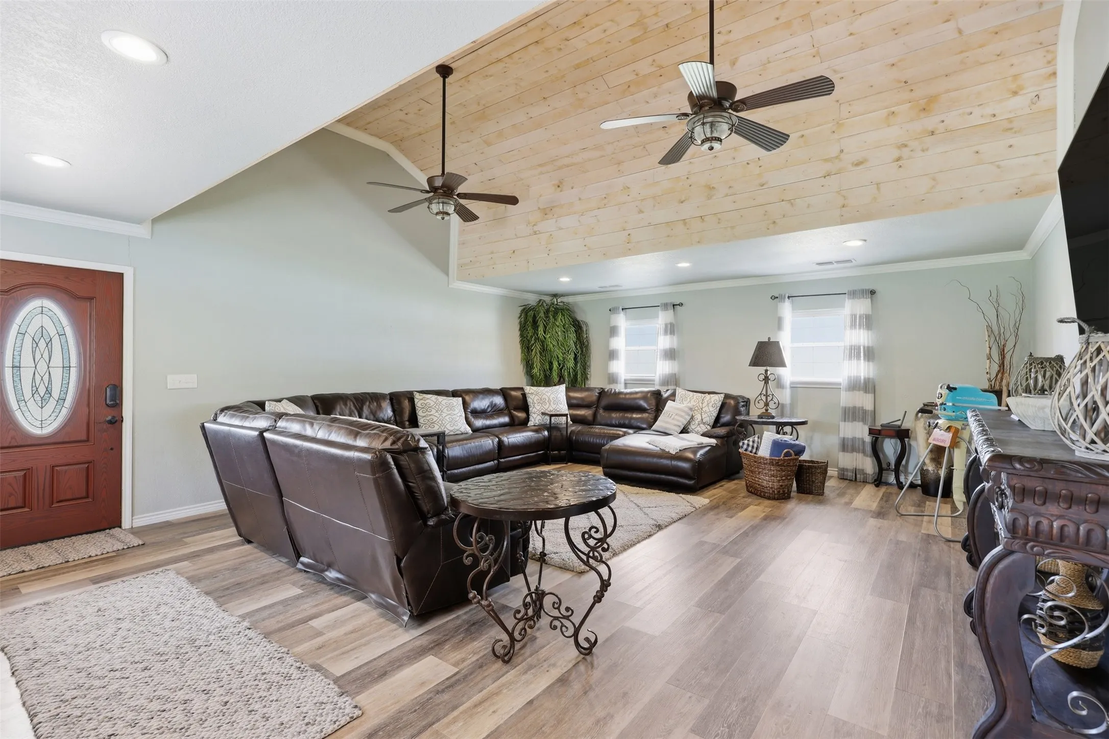 Spacious living area featuring a vaulted wood-finish ceiling, two ceiling fans, wood-finish flooring, and recessed lighting
