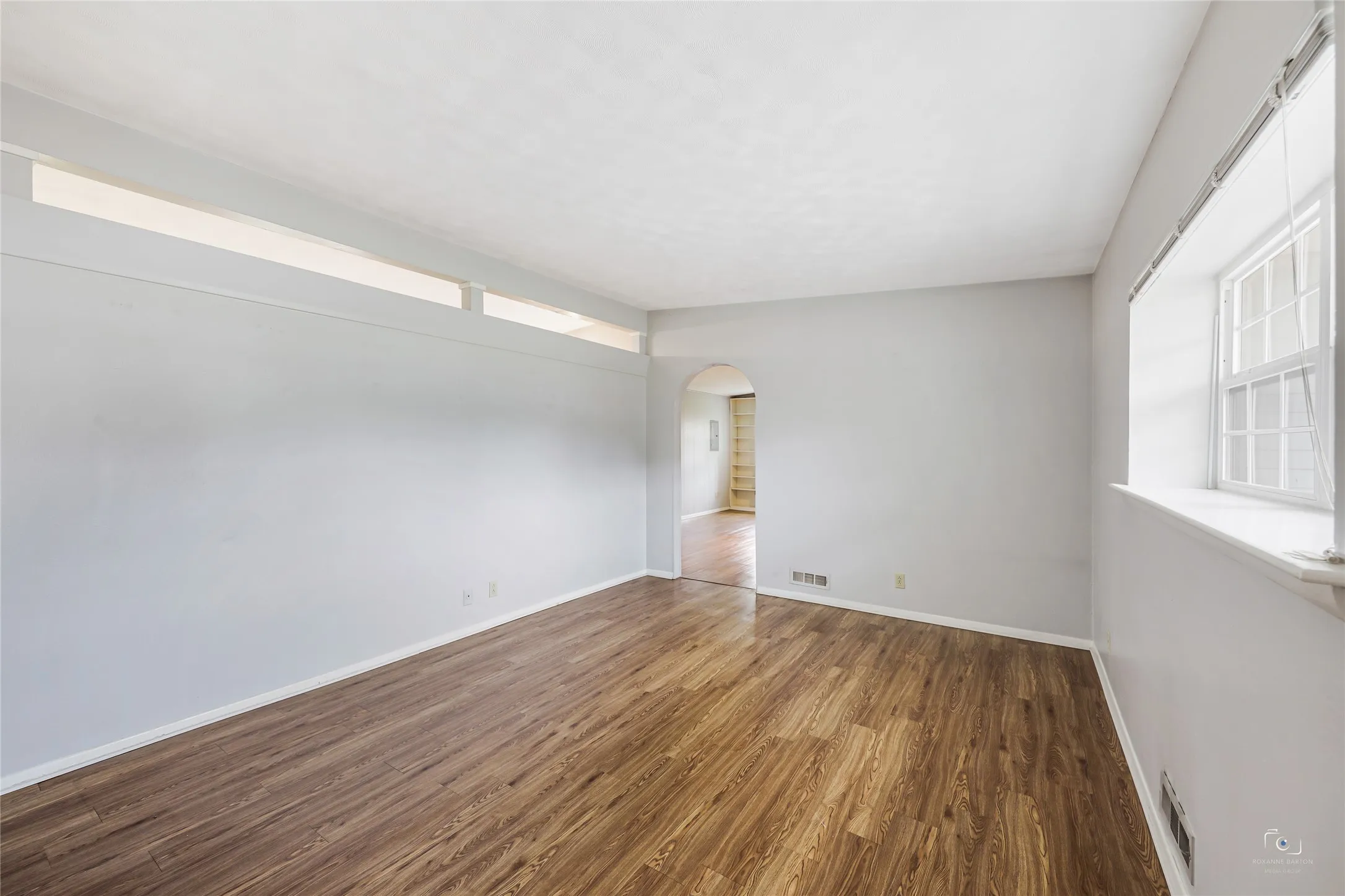 Spacious front living area with great wall space for furniture and front Pella window views the front yard courtyard and offers window coverings as well ideal nice sized window  ledge for plants, knick knacke etc.