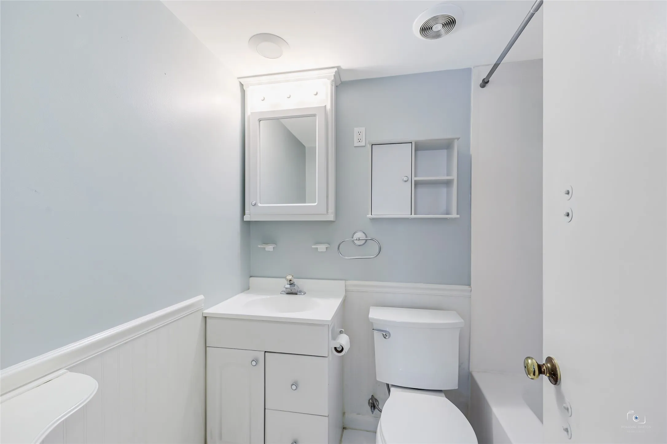 Views of one of the bathroom which offers a tub-shower option, fabulous decorative accessory ledge, medicine cabinets and harware for towel, toilet paper, shower  as well as sink with drawers and under cabinet storage! Outside this bathroom - additonal dual hampers and storage with a window!