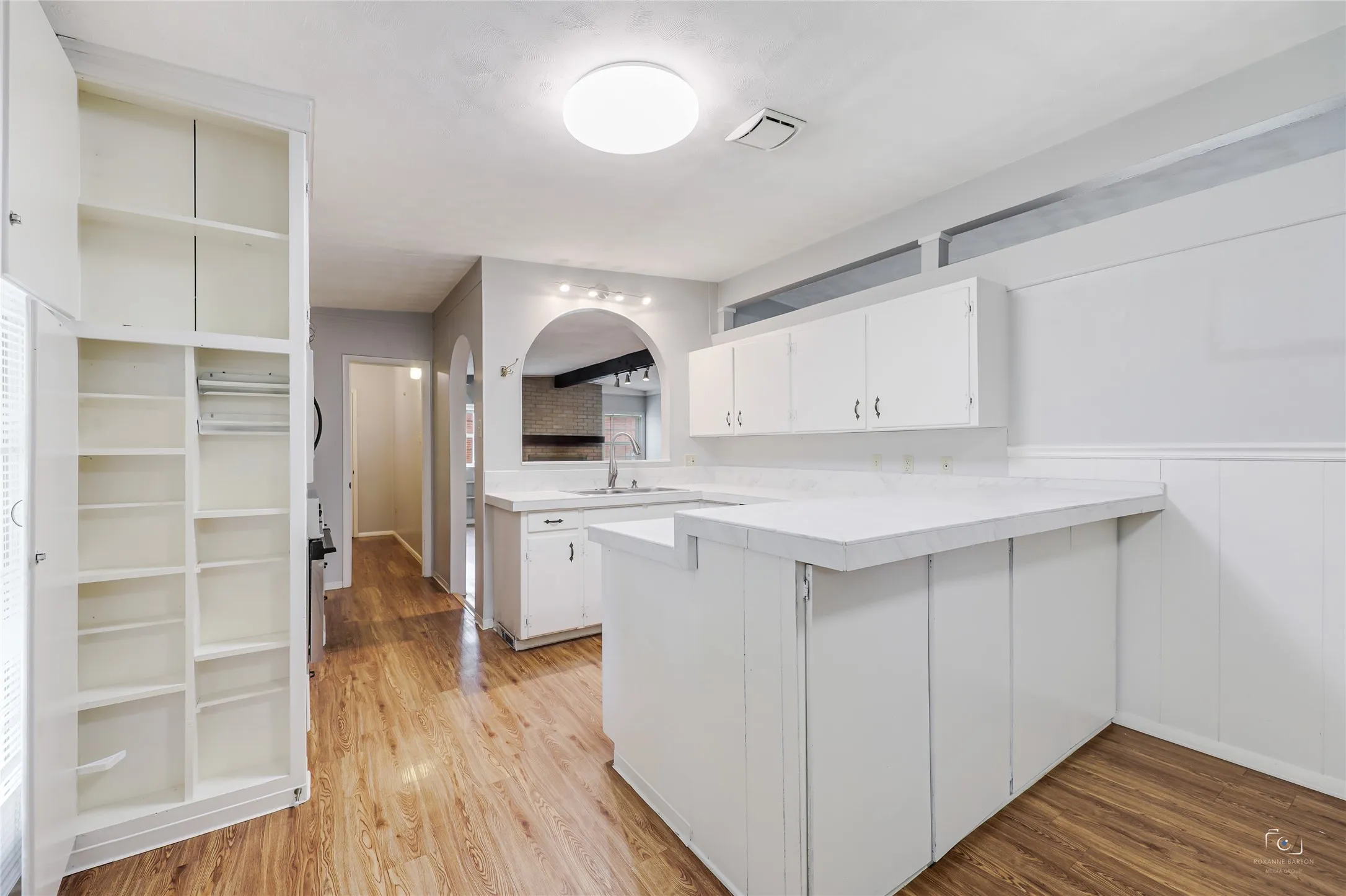 Showing this handy built-in cabinet - ideal spice rack storage , counter tops and storage under the breakfast bar as well as extensive vinyl wood like vinyl flooring!