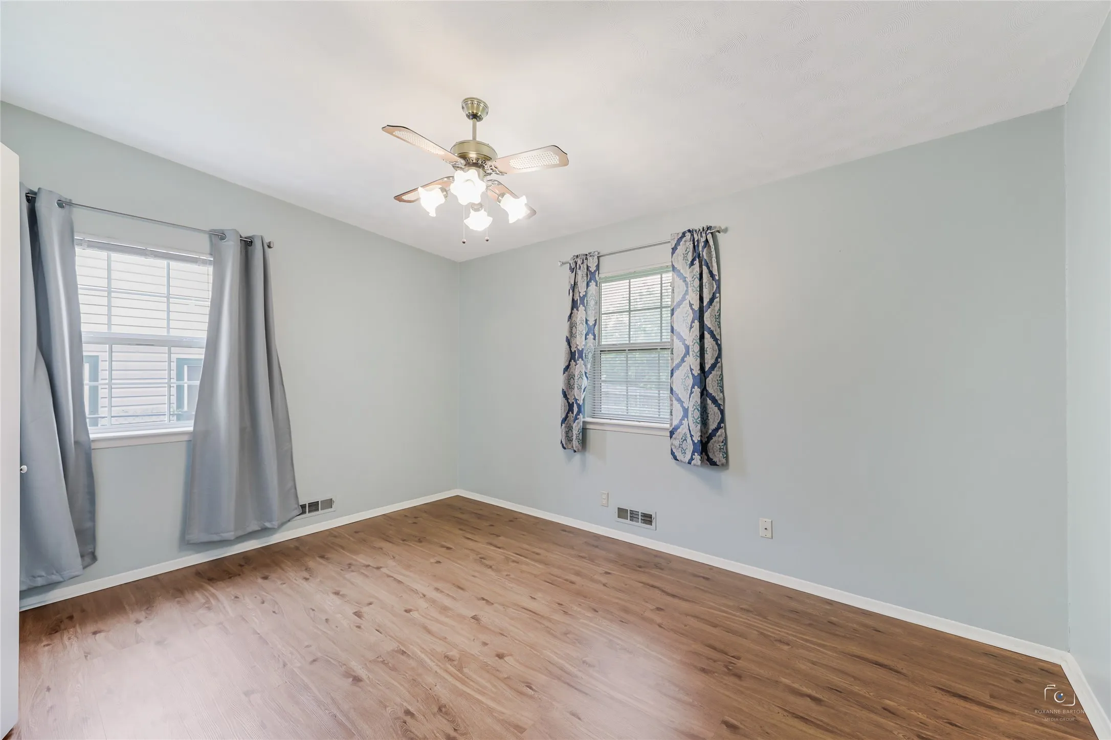View of one of the three bedrooms - all bedrooms have ceiling fans, no carpet, windows with window coverings and lovely painted ceiling treatment!