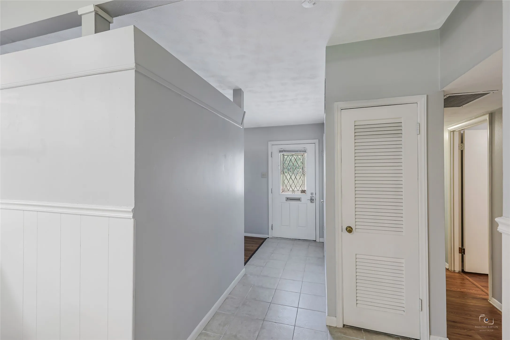 Tiled foyer with a coat closet and easy access to  one of the living areas-with special uplighting from kitchen between rooms!  Great floorplan ideal for an office or extra playroom etc...